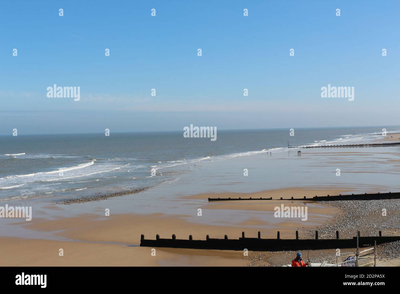 Cromer Sandstrand an einem sonnigen Tag mit ruhigem Meer an einem Nordseestrand in England, Norfolk, Großbritannien, Seestrand Stockfoto