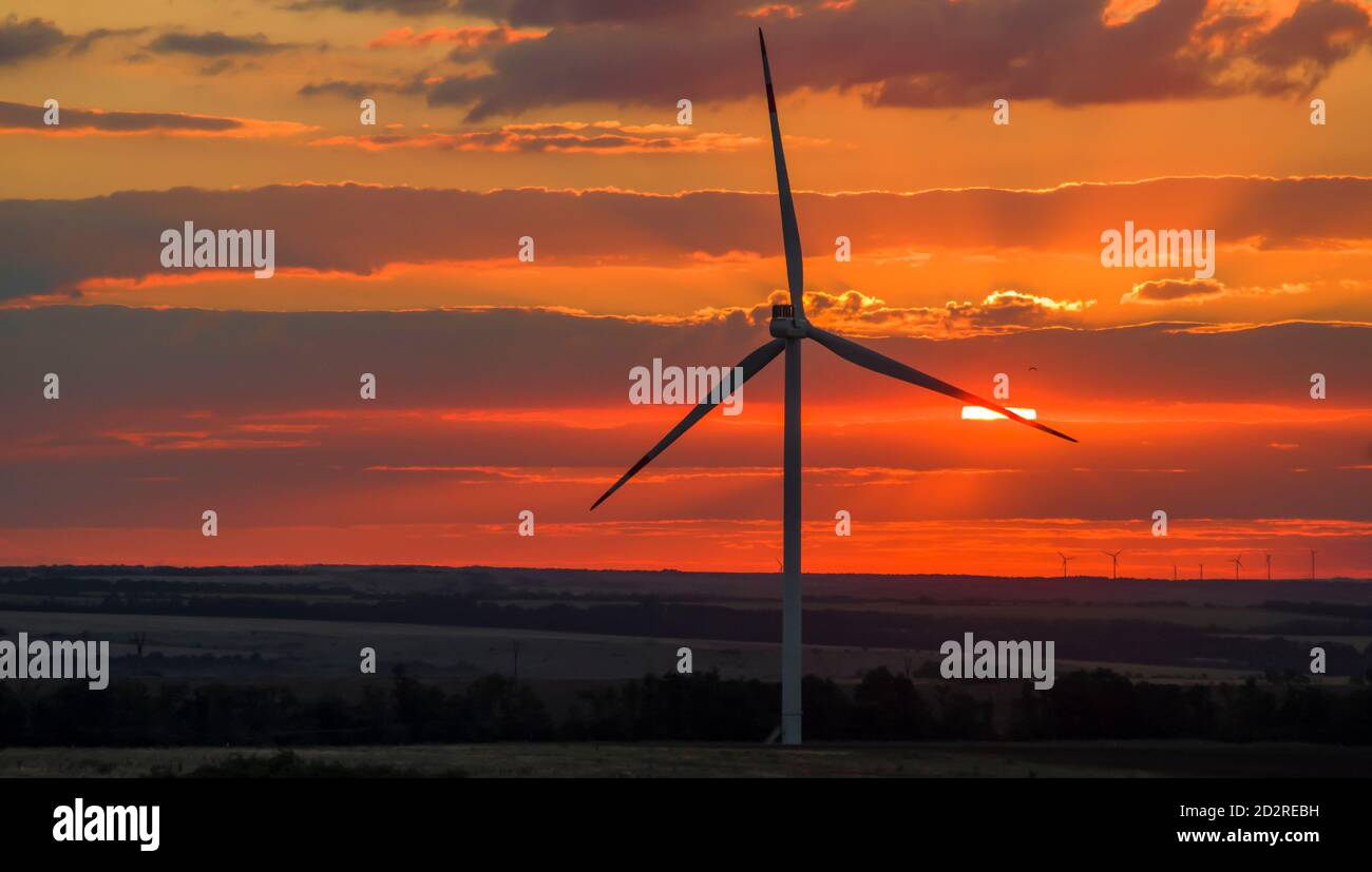 Windkraftanlagen, die Strom erzeugen. Umweltfreundlicher Strom. Sonnenuntergang Stockfoto