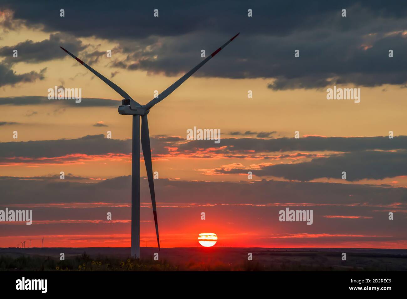 Windkraftanlagen, die Strom erzeugen. Umweltfreundlicher Strom. Sonnenuntergang Stockfoto