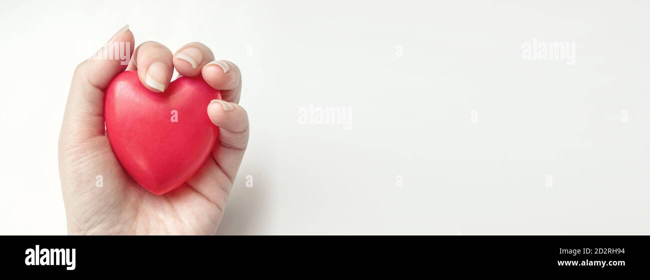 Hand halten rotes Herz, Gesundheitsversorgung, spenden und Familienversicherung Konzept. Welt Herz Gesundheit Tag Idee Stockfoto
