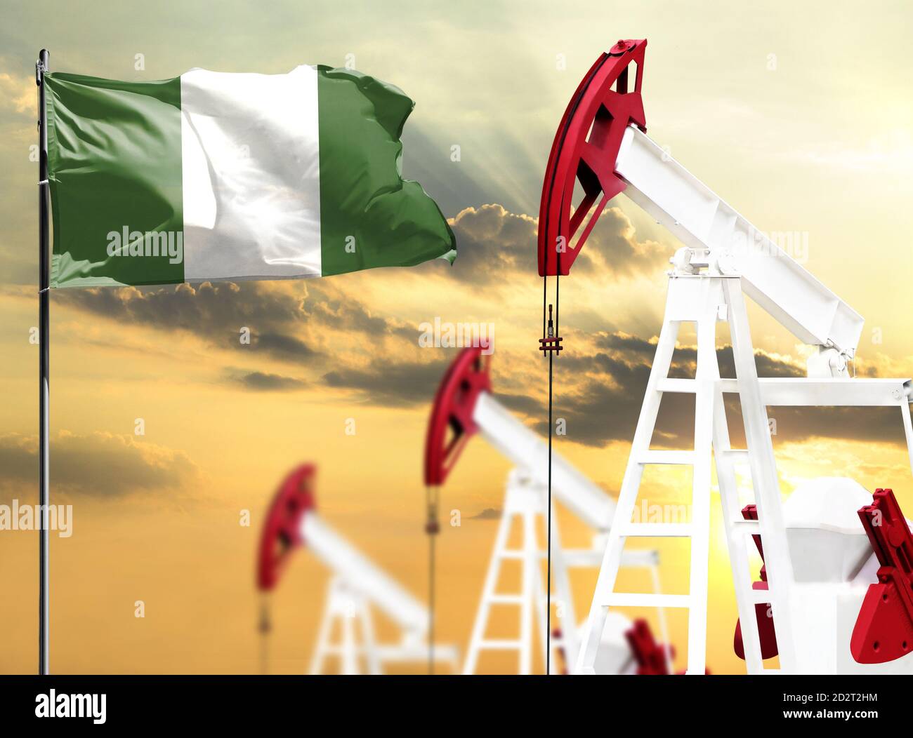 Ölbohrinseln vor dem Hintergrund des bunten Himmels und einer Fahnenstange mit der Flagge Nigerias. Das Konzept der Ölproduktion, Mineralien, Entwicklung von neuen Stockfoto