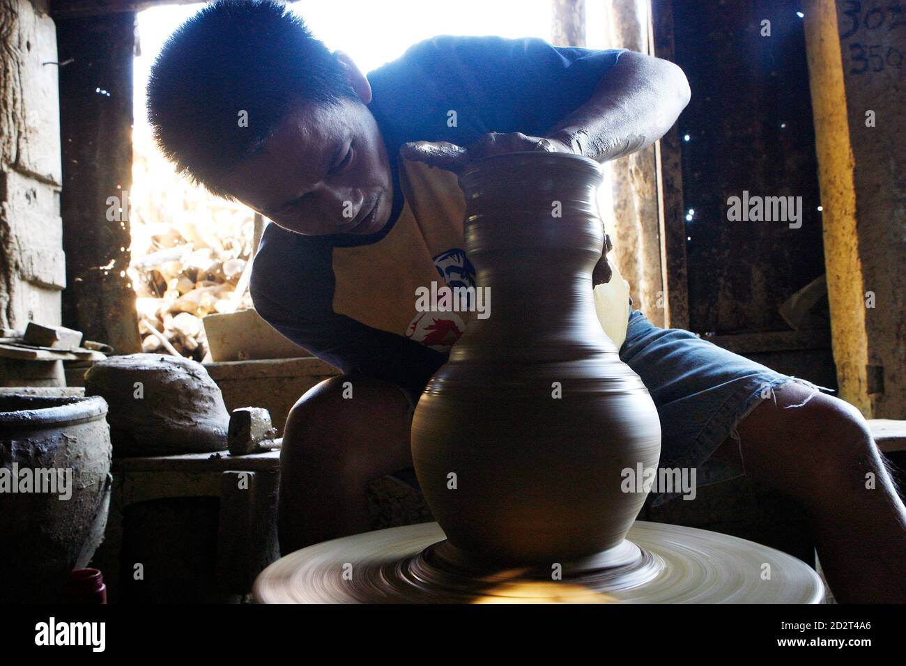 Eduardo Go, 39, ein Keramik-Hersteller, formt einen Topf aus Ton in einer  Lagerhalle in Vigan City, Provinz Ilocos Sur, nördlich von Manila 23.  Januar 2010 gemacht. Keramik gehört zu den traditionellen Industrien