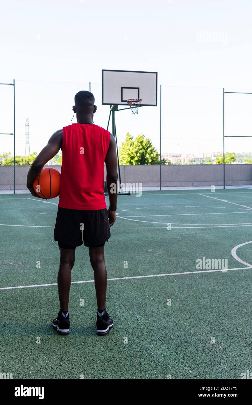 Rückansicht des afroamerikanischen männlichen Spielers im Sportswear Stehen Mit Basketball auf dem Spielplatz und Blick weg Stockfoto