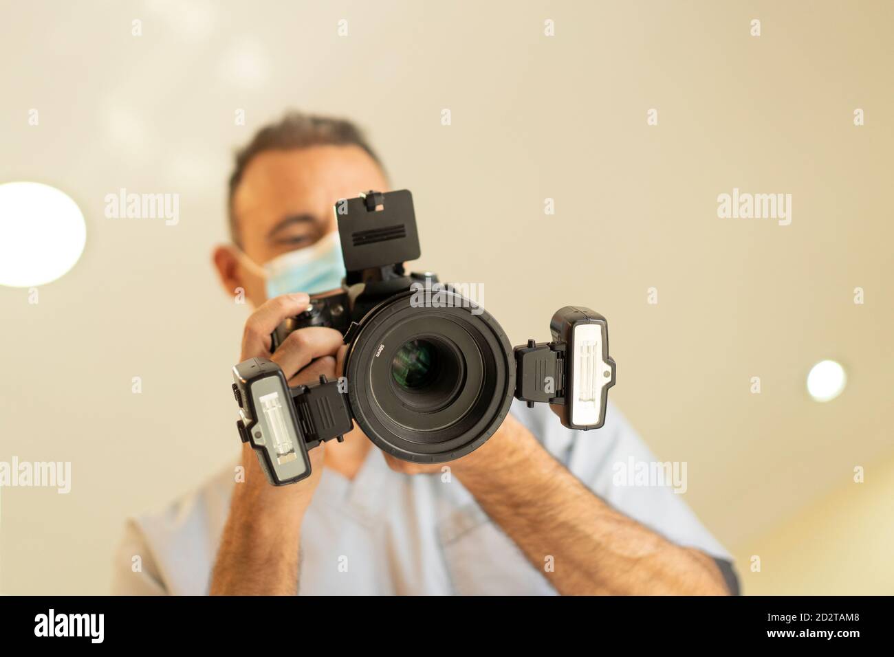 Low-Winkel-Ansicht des Zahnarztes Arzt hält ein professionelles Foto Kamera mit Ringblitz Stockfoto