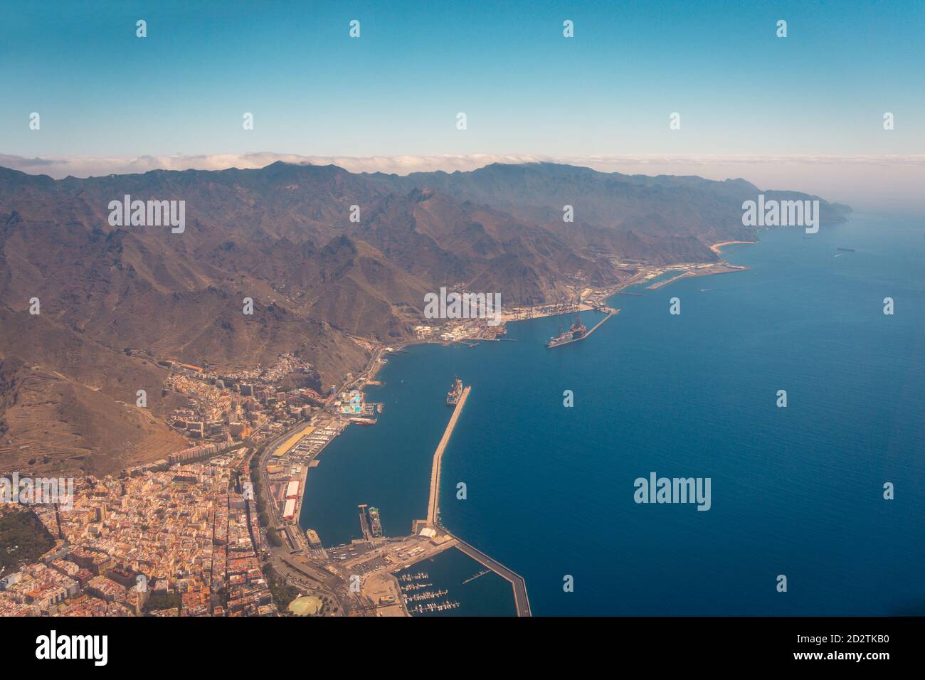 Luftaufnahme eines Teils der modernen Flugzeuge fliegen über erstaunlich Bergige und küstennahe Hafenlandschaft am Morgen auf Teneriffa Stockfoto