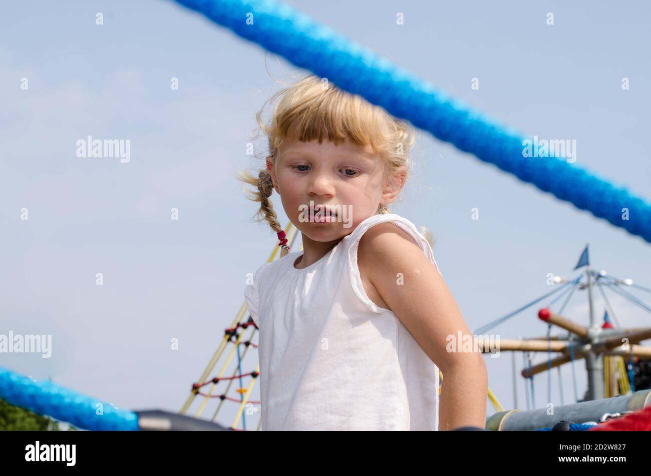 Schöne blonde Mädchen spielen auf dem Spielplatz Stockfoto