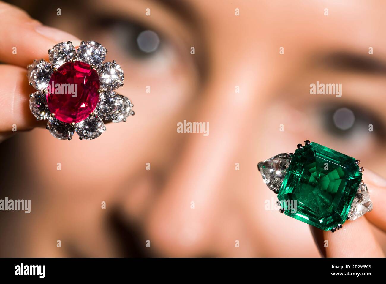 Ein Modell zeigt einen 7.03 Karat ovalen birmanischen Rubin in einem  Diamant-Cluster-Ring und einen 12.79 Karat kolumbianischen Smaragd- und  Diamantring während einer Auktionsvorschau bei Christie's in Genf, 13.  November 2009. Die Ringe