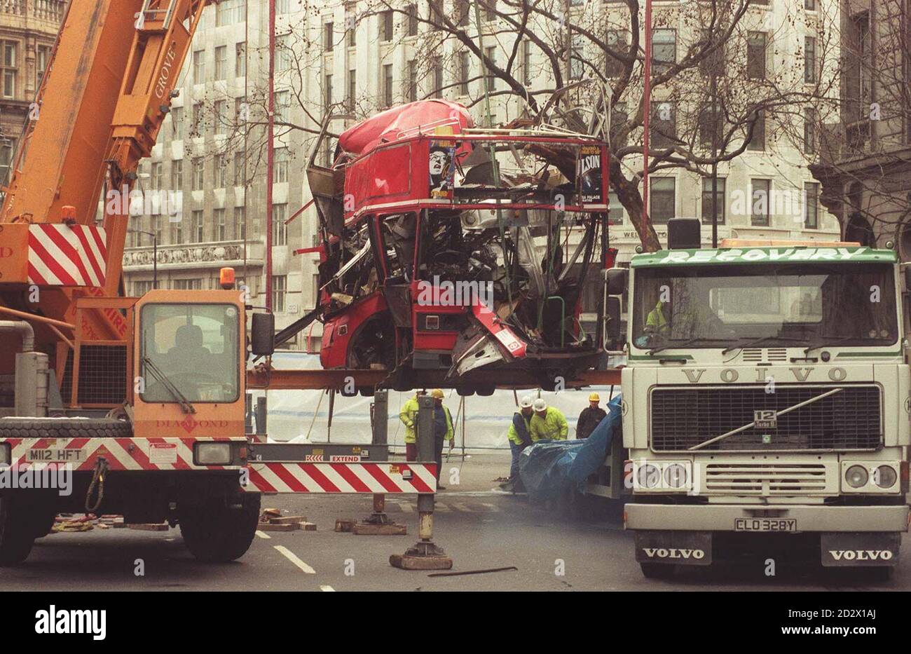 Arbeiter bereiten sich darauf vor, das Wrack des bombardierten Doppeldeckerbusses am Aldwych in London zu heben. Stockfoto