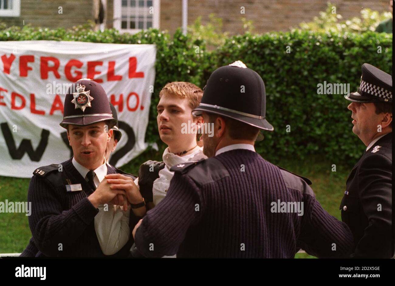 Ein Demonstrator wird heute (Freitag) von der Polizei in Aberystwyth bei einem Protest von rund 200 walisischen Sprachschülern über den Besuch der Königin in der Stadt weggeführt. Der königliche Besuch wurde zu einem abrupten Ende gebracht, als die Königin ihr Engagement an der University of Wales auf Anraten ihres persönlichen Schutzbeauftragten und Dyfed-Powys-Assistenzchefs Keith Turner absagte. Stockfoto