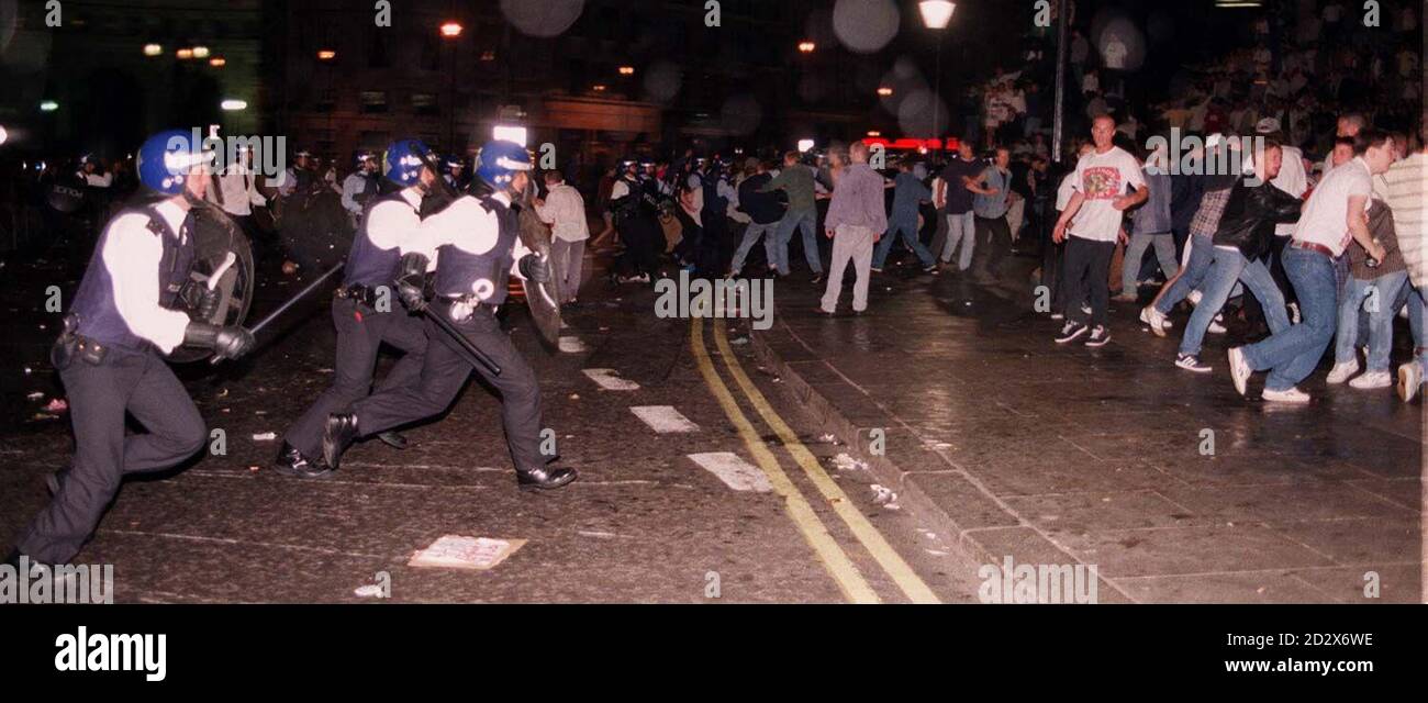 Die Polizei in Bereitschaftsspielzeug angeklagt Fußballfans, die sich am Mittwochabend auf dem Londoner Trafalgar Square versammelten, nachdem England im Halbfinale des Euro'96-Fußballwettbewerbs von Deutschland geschlagen worden war. Mehrere Fans wurden verletzt und einige Personen wurden ins Krankenhaus gebracht. Bild von Martin Keene/mk Stockfoto