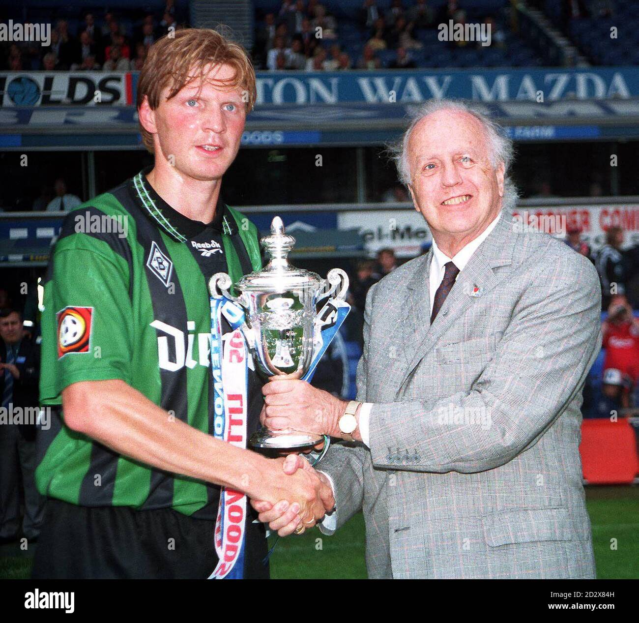 Brussia Mönchengladbachs Steffan Effenberg holt die John Moores Centenary Trophy von Sir John Moores, nachdem sie den FC Porto im Finale im Goodison Park besiegt hat. *05/03/04: Die sieben besten Liverpool-Verdiener werden als John Moores und Familie aufgeführt. Im Wert von 1,24 Milliarden (wie im Vorjahr). Platz 21 national. Die Familie Moores vergab ihr Geld in den Littlewoods Geschäften und im Versandhandel sowie in den Littlewoods Pools. Die Familie verkaufte vor zwei Jahren das letzte ihrer Geschäftsinteressen. Viele Mitglieder leben im Ausland, aber der Leiter der Familie, John, lebt immer noch in Formby und sein Cousin David ist Stockfoto