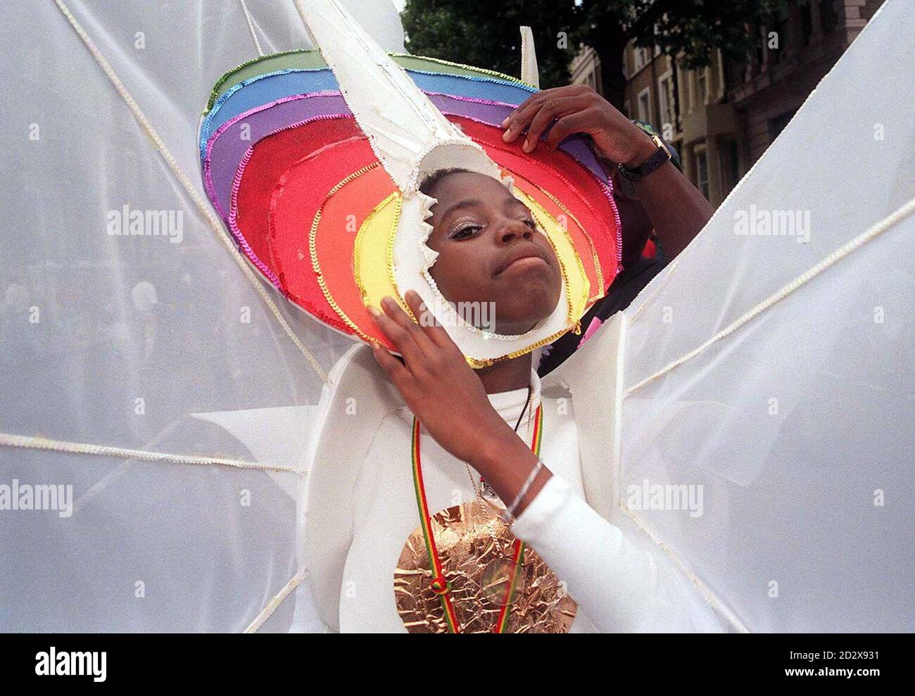 Ein junger Faschingsgänger hat ihr Kostüm heute (Sonntag) mitten in der Prozession am Notting Hill repariert, nachdem die jährliche Feiertagswochenende-Party zu einem regnerischen Start ausging. Siehe PA Geschichte SOCIAL Carnival. Foto von Stefan Rousseau/PA Stockfoto