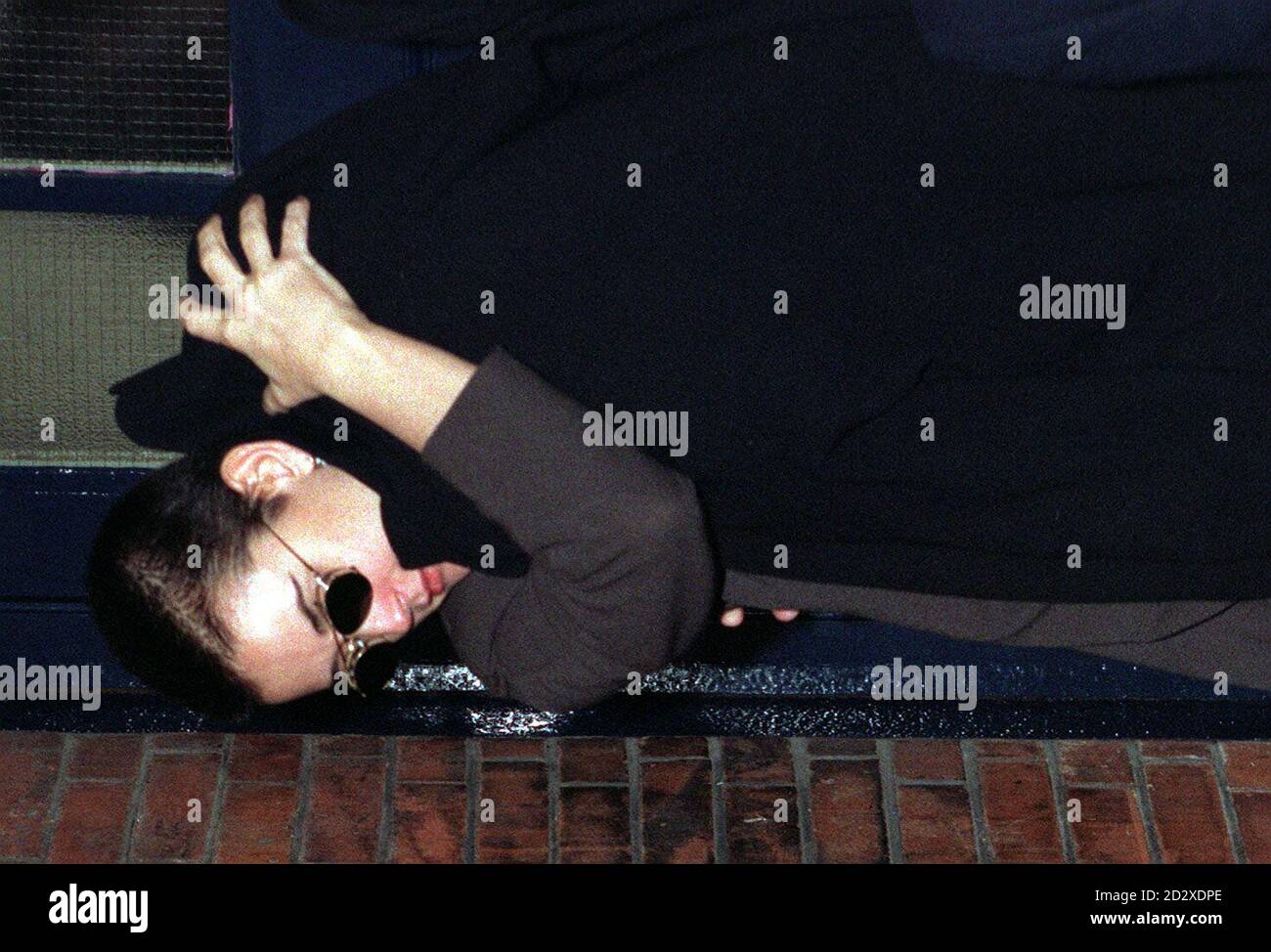 Die Hollywood-Schauspielerin Demi Moore bedeckt ihr Kind mit einem Mantel, als sie aus der Hintertür des Londoner Palladium auftauchte, nachdem sie die Matinee-Aufführung von 'Oliver!' gesehen hatte. Heute (Mi). Foto von John Stillwell/PA. Stockfoto