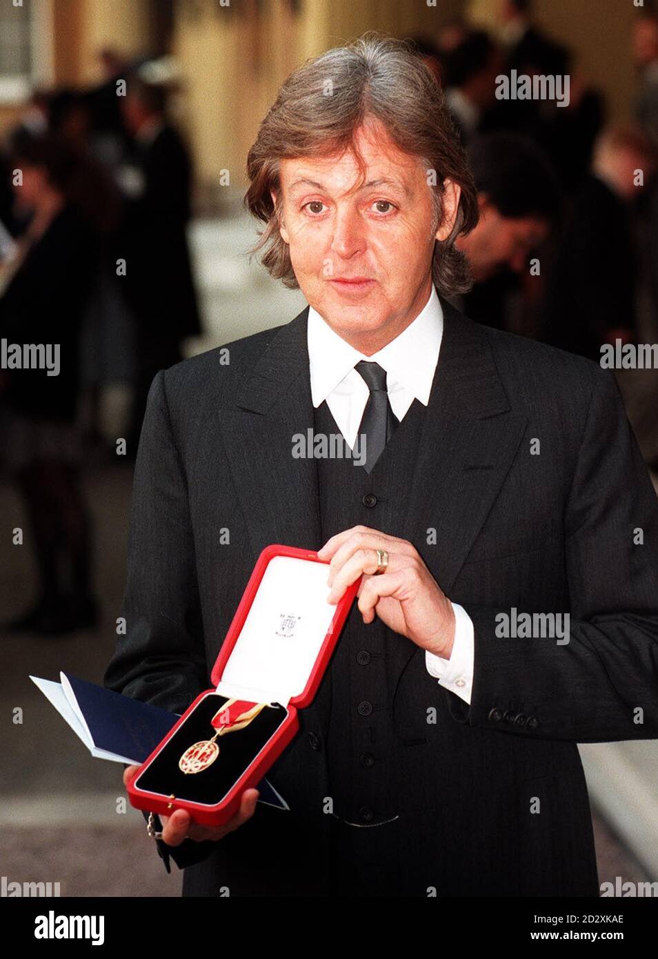 Sir Paul McCartney zeigt seine Medaille, nachdem er seine Ritterschaft von der Queen bei der heutigen (Dienstag) Investiturfeier des Buckingham Palace erhalten hatte. * 3/10/02: Sir Paul McCartney und Ringo Starr werden ein Tribute-Konzert in Erinnerung an Beatle George Harrisons headeln, das heute, Donnerstag, den 3. Oktober 2002, angekündigt wurde. Die Veranstaltung findet am 29. November in der Londoner Royal Albert Hall statt und zeigt einige der größten Namen der britischen Musik. Tickets sind am nächsten Freitag erhältlich und kosten zwischen 25 und 150. Stockfoto