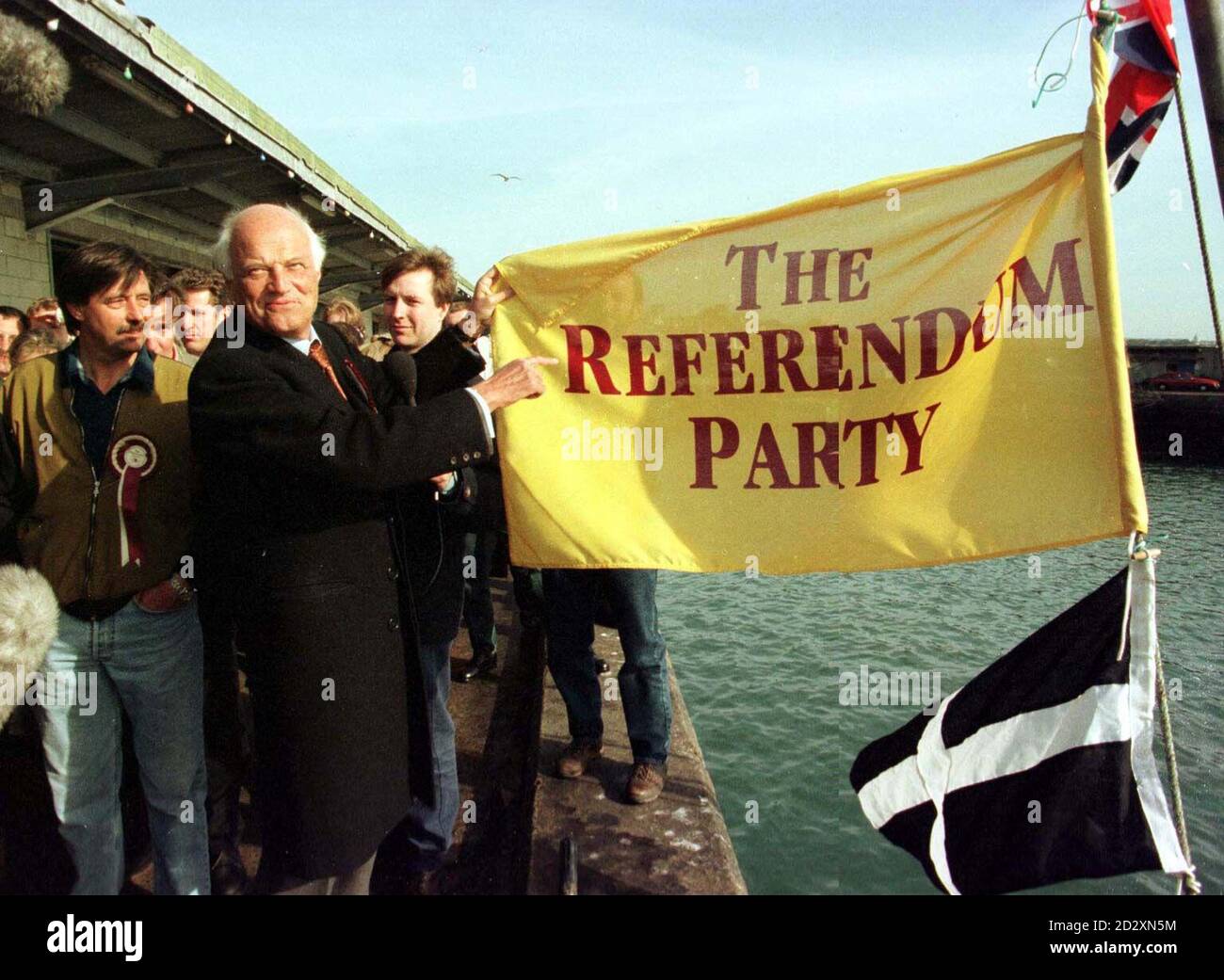 Sir James Goldsmith hisst heute (Dienstag) eine Volksentscheidungspartefahne, um die Kampagne der Partei im kornischen Fischereihafen Newlyn, St. Ives, zu starten, während der Kandidat für das Referendum Mick Faulkner (links) anschaut. Siehe PA Geschichte WAHLREFERENDUM. PA-Foto. Stockfoto