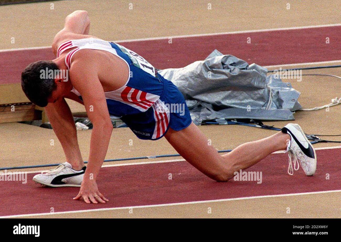 Jonathan Edwards Stretching letzte vor einem Sprung im Olympiastadion. Der Dreifachspringer wurde Zweiter im Finale und holte eine Silbermedaille. Stockfoto