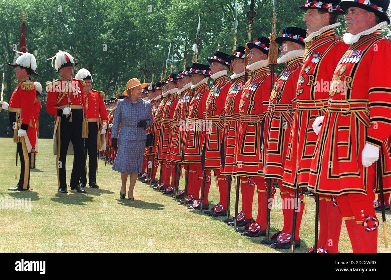 Die Königin inspiziert die Yeomen der Garde auf dem Gelände des Buckingham Palace in London. 02/05/01: Die Königin war im Schritt mit der Geschichte, als sie das Yeomen der Garde, wahrscheinlich das älteste noch aktive Militärkorps der Welt, inspizierte. * in Tudor-Uniformen gekleidet - scharlachrote Dubletten, Hosen, rote Strümpfe, weiße Rüschen und schwarze Samthüte - bilden sie den zeremoniellen Leibwächter der Königin aus dem Jahr 1485. Stockfoto