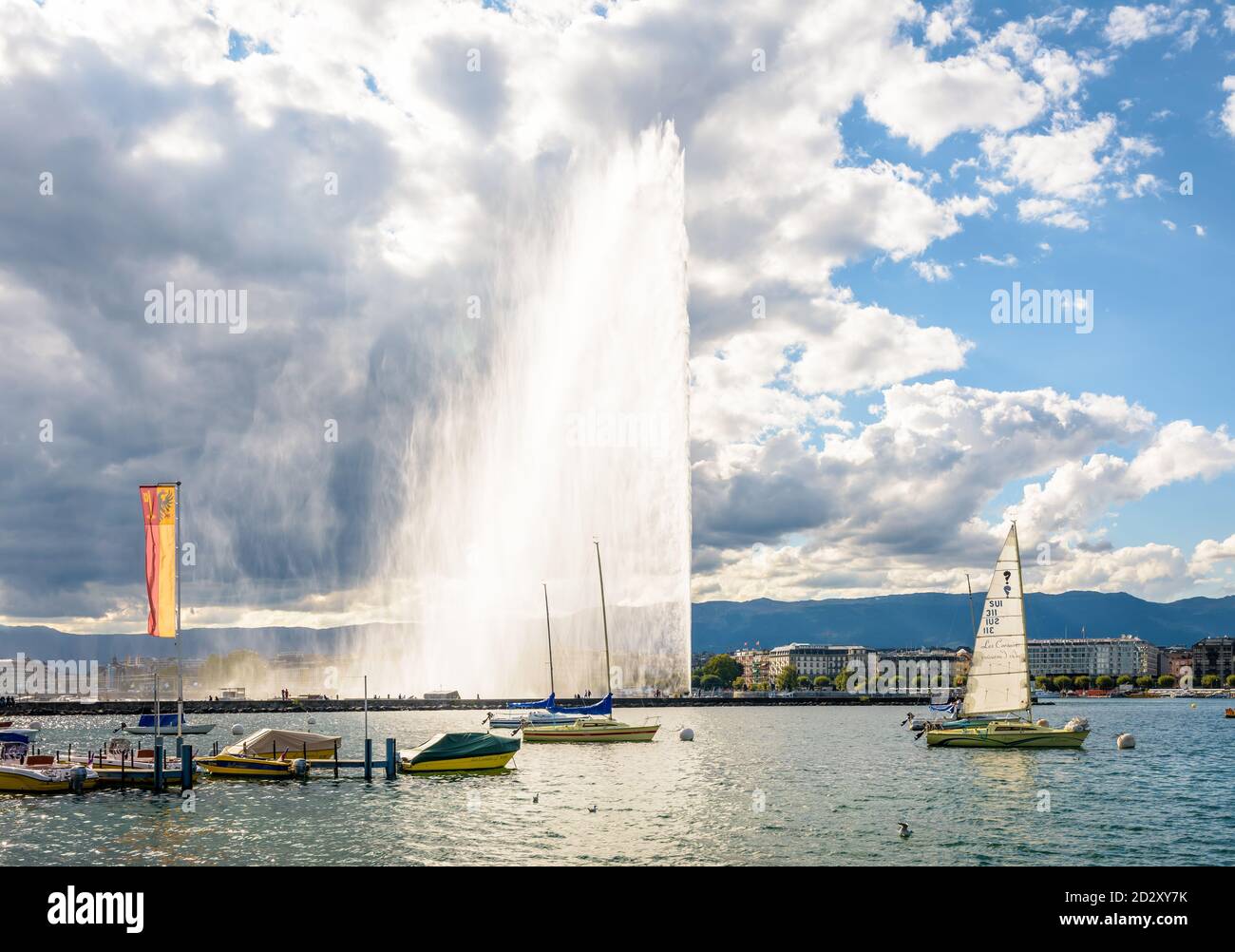 Der Jet d'Eau in der Genfer Bucht, Schweiz, der 140 Meter hohe Wasserstrahl auf dem Genfersee, Wahrzeichen der Stadt, an einem stürmischen späten Nachmittag. Stockfoto
