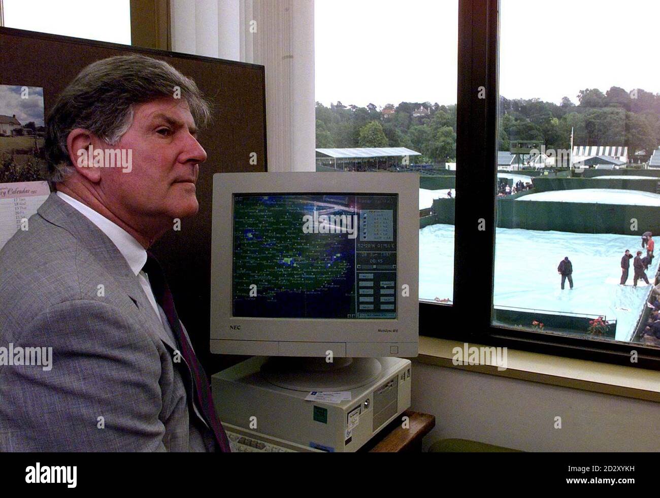 Wimbledon Tournament Schiedsrichter Alan Mills schaut über die nassen überdachten Außenplätze, während er auf den "IST" Computer des Wetteramtes blickt, der genau den Zustand des Wetters im ganzen Land zeigt. Heute (Sa) wird entschieden, ob Wimbledon morgen, in der Regel ein Ruhetag, eröffnet wird, um die 250 plus nicht gespielten Spiele aufzuholen. Foto von Adam Butler/PA/EDI Stockfoto