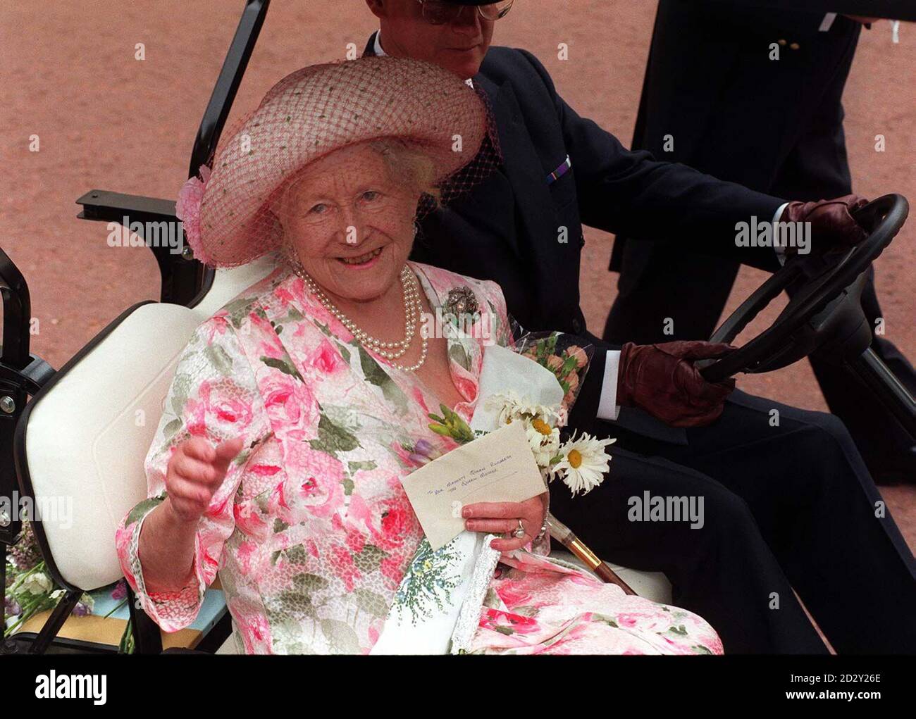 Die Queen Mother winkt den Scharen von Wohlläufern zu, die sich heute (Mon) vor ihrem Londoner Zuhause versammelt hatten, als sie in ihrem "Queen Mom Mobile" nach dem traditionellen Tribut des Royal Regiment of Wales an sie an ihrem 97. Geburtstag vertrieben wird. Siehe PA Geschichte KÖNIGLICHE Mutter. Foto Stefan Rousseau/PA Stockfoto