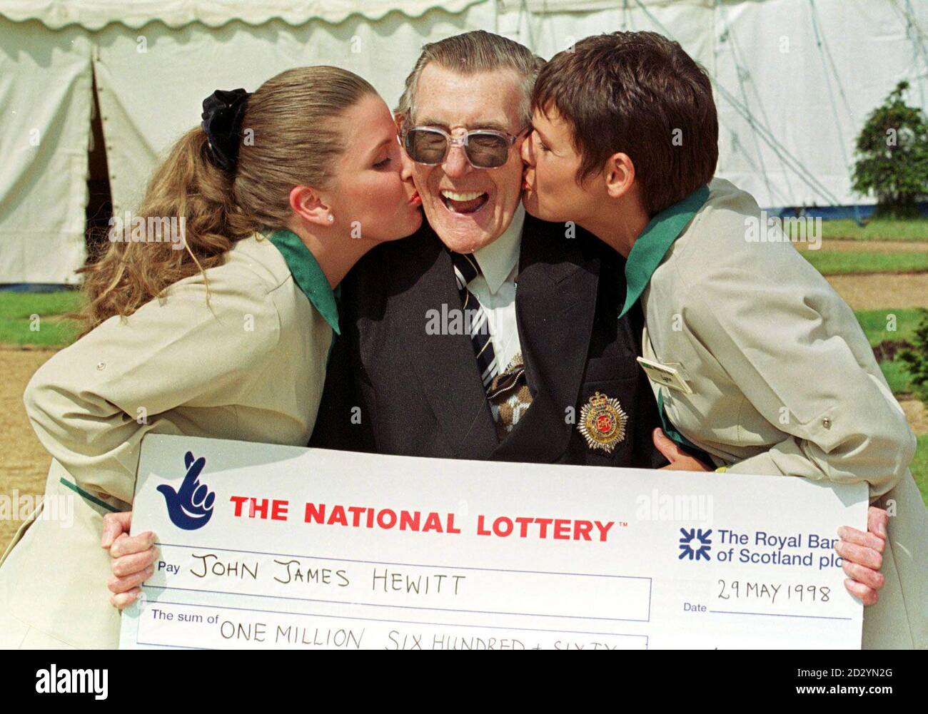 Großbritanniens ältester Lotteriegewinner, Jack Hewitt, 79 aus Merseyside, erhält einen Kuss von der Asda Lottery Till Girls, Samantha (links) und Lynn, der ihm sein Gewinnticket verkaufte, nachdem er heute (Freitag) seinen Scheck über den 1.6-Millionen-Jackpot erhalten hatte. Der Urgroßvater holte seinen Sieg in der Ziehung am Mittwoch (27.05.98) mit den gleichen Zahlen, die er jede Woche seit dem Start der Lotterie gewählt hat. Siehe PA Geschichte LOTTERIE Ziehung. (NEG) Foto von Dave Kendall/PA Pic Dave Kendall. Stockfoto