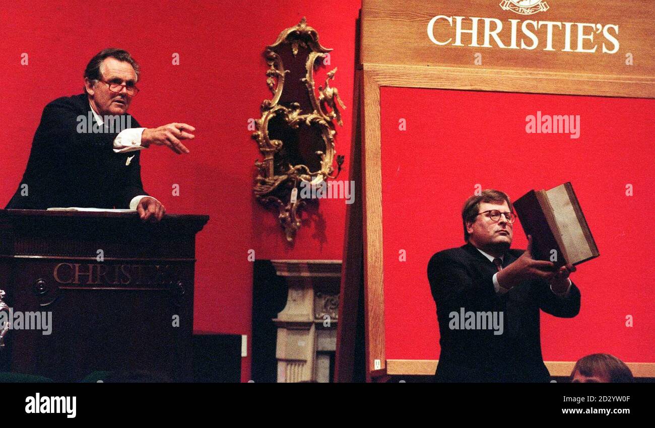 Der Auktionator Lord Himdlip (links) fängt den Bieter ein, da die erste Ausgabe von Chaucers Canterbury Tales aus dem 15. Jahrhundert, gedruckt von William Caxton (rechts abgebildet), heute Abend (Mittwoch) für einen Rekord von 4,621,500 über dem sechsfachen des geschätzten Preises bei Christie's in London verkauft wird. Siehe PA Story SALE Chaucer. Foto von Neil Munns/PA Stockfoto