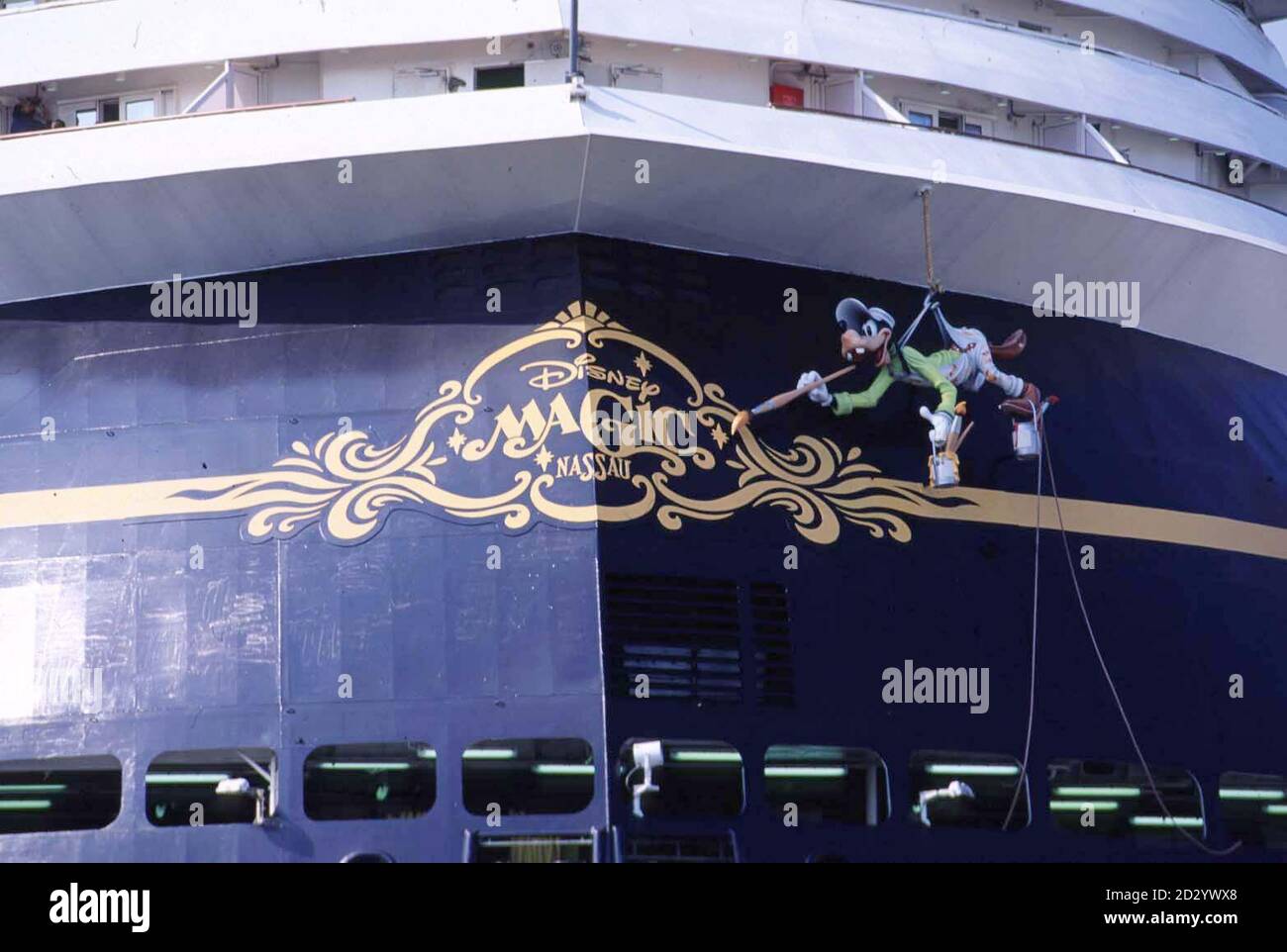 Goofey bringt den letzten Schliff zum neuen Disney Kreuzfahrtschiff, dem Disney Magic, das auf seinen elf Passagierdecks Platz für 2,400 Gäste bietet. Das Schiff ist eine neue Richtung für das Unternehmen, besser bekannt für seine Unterhaltung und Themenparks. Die sieben-Tage-Urlaubspakete kombinieren eine drei- oder viertägige Reise nach Walt Disney World in Florida mit einer drei- oder viertägigen Kreuzfahrt auf den Bahamas. Das 83,000-Tonnen-Schiff, eines der größten der Welt, wird von Port Canaveral in Florida aus segeln, den historischen Hafen von Nassau anlaufen und einen Tag auf Disneys eigener privater Vergnügungsinsel auf den Bahamas verbringen, gegossen Stockfoto