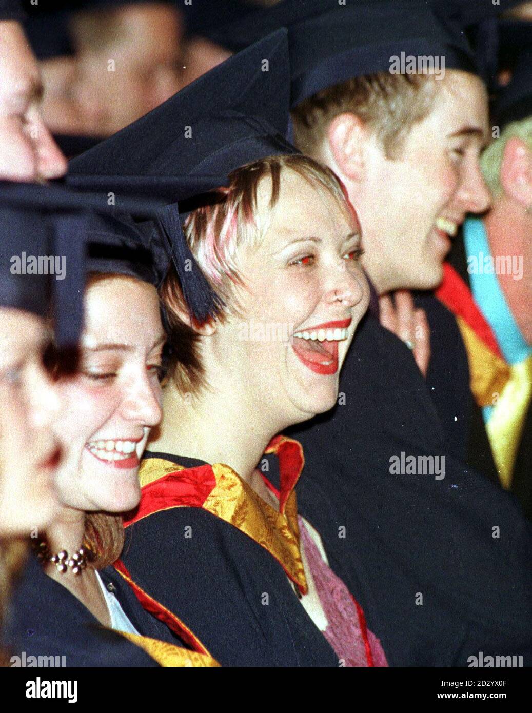 Rosa Rockerin Julie Thompson (Mitte), deren gefärbtes Haar und die lockere Natur die Königin Anfang dieses Jahres beeindruckten, vertuschte heute ihre Schlösser - als sie die Fame-Schule abschloss. Julie, 21, aus Norwich, wurde berühmt, als sie und ihre Gruppe, Camp Houston, im Buckingham Palace auftauchten, um Weltführer zu unterhalten, erhielt ihren Abschluss bei einer Zeremonie an der Liverpools John Moores Universität heute (Dienstag). Siehe PA Story SHOWBIZ Fame. Foto von Dave Kendall/PA. Stockfoto