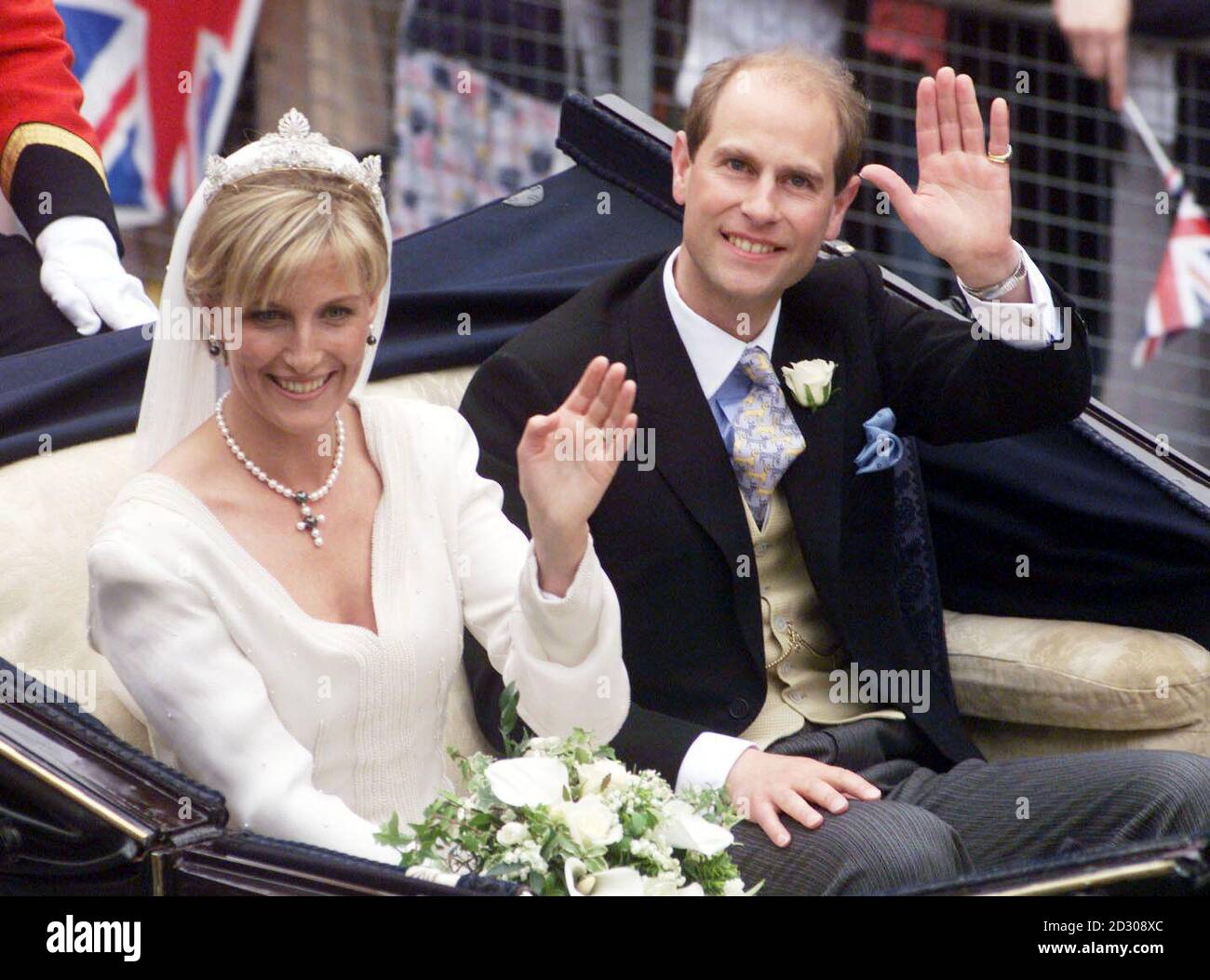 Ein lächelnder Prinz Edward und Sophie Rhys-Jones winken nach ihrer Hochzeit in der St. George's Chapel in Windsor Castle zu den Massen. Das königliche Paar wird nach ihrer Ehe als Graf und Gräfin von Wessex bekannt sein. Stockfoto