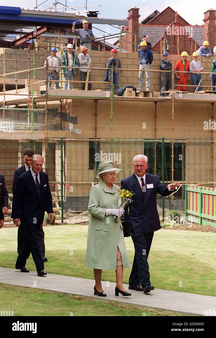 Die britische Königin Elizabeth und der Herzog von Edinburgh passieren eine Baustelle, während sie die Garston Village Hall in Liverpool während ihres Besuchs in der Stadt besuchen. Stockfoto