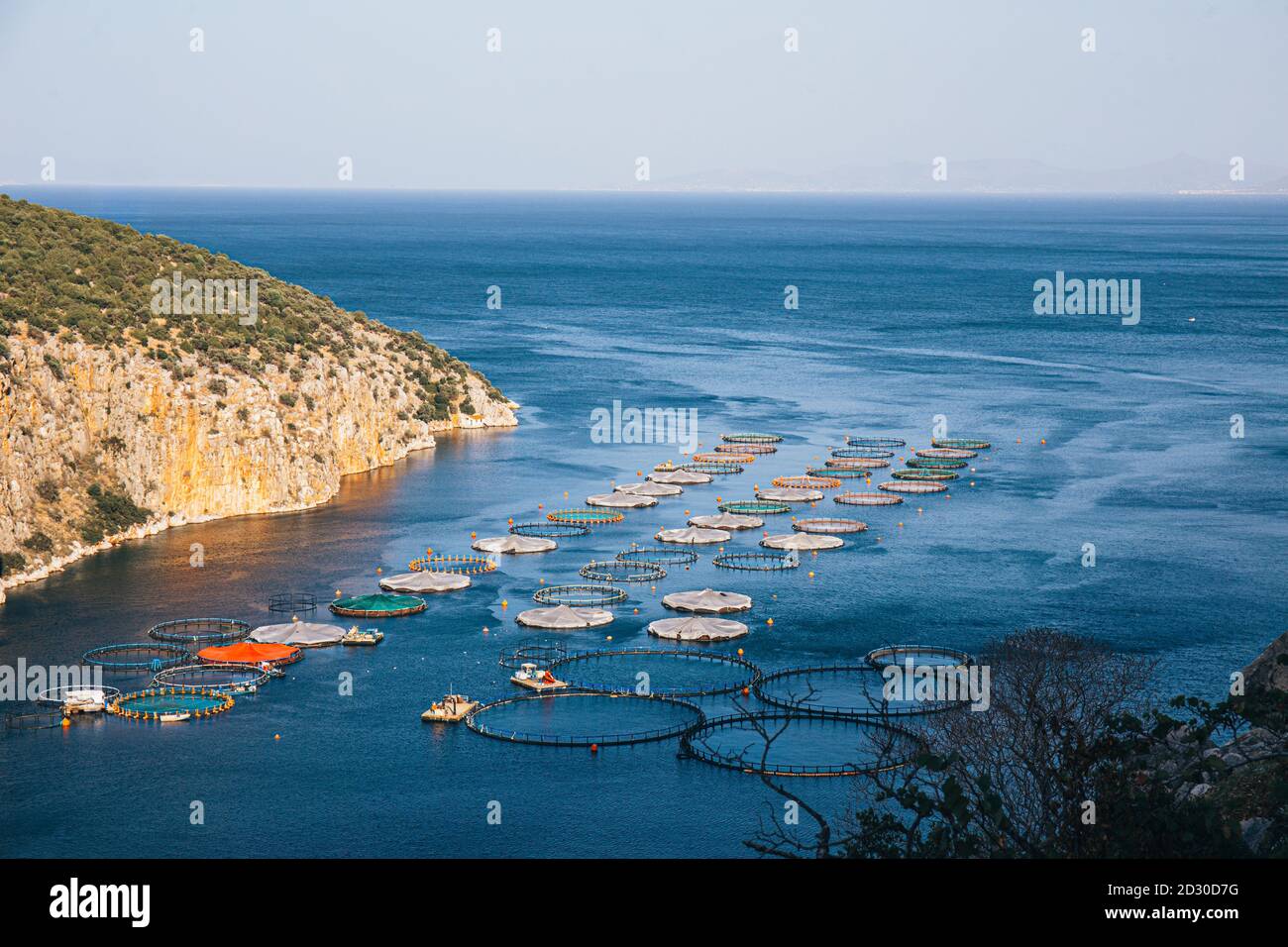 Fischfarm. Käfige für die Fischzucht dorado und Seabass. Die Arbeiter füttern die Fische ein Futter. Meereslandschaft Fotografie. Stockfoto