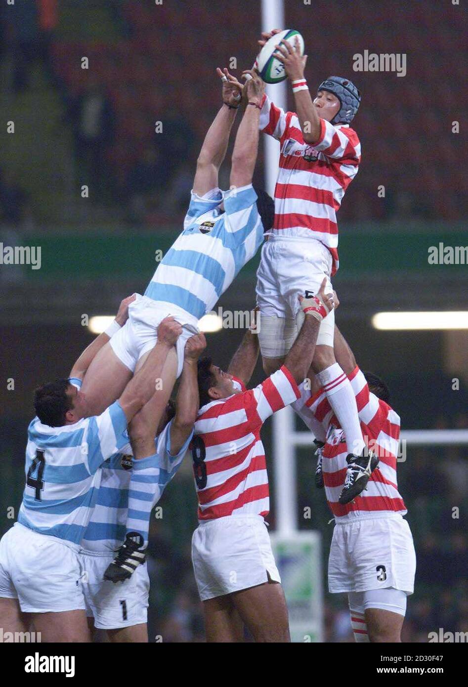 Der japanische Hiroyki Tanuma hebt sich während eines Rugby-Weltcupspiels im Millennium Stadium, Cardiff, Wales, in einer Line-Out-Reihe über die argentinischen Spieler. Stockfoto