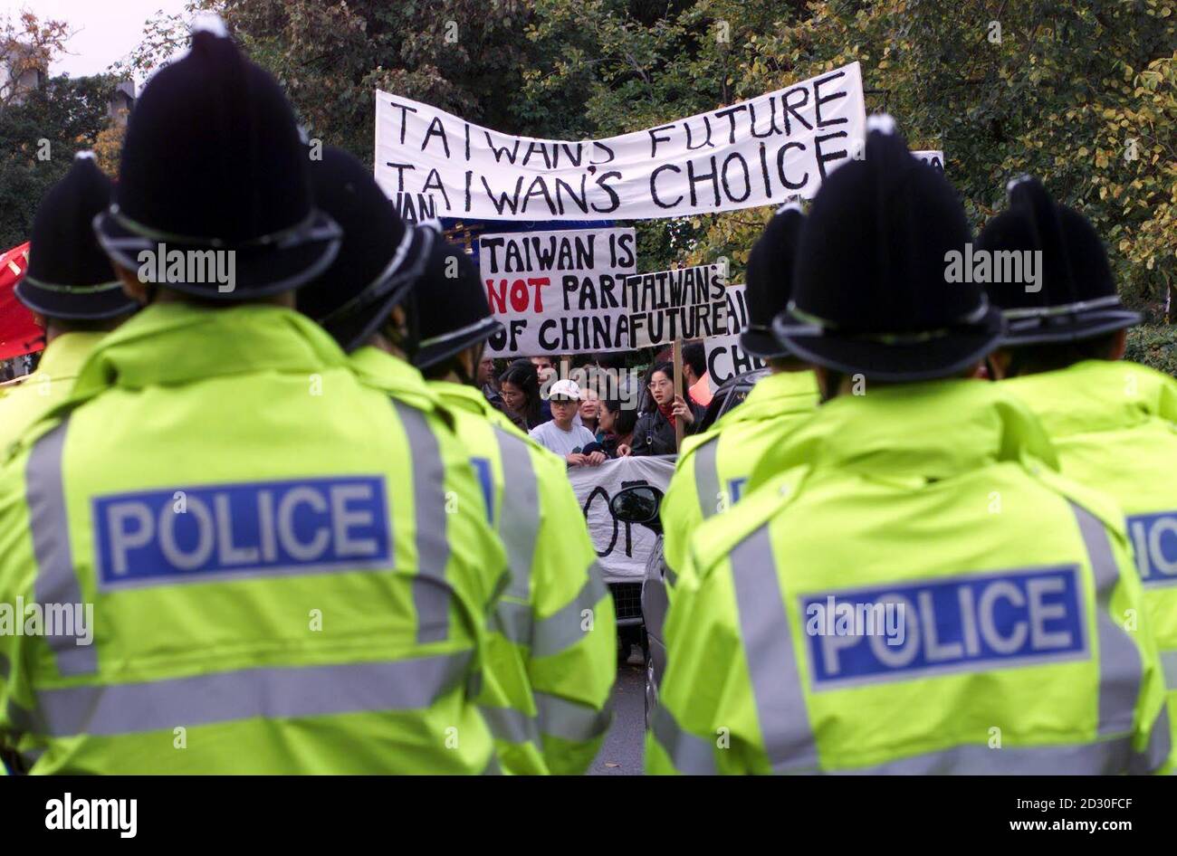 Antichinesische Demonstranten machen sich Gehör, als der chinesische Präsident Jiang Zemin am letzten Tag seines Staatsbesuches in Großbritannien eine Musikschule an der Universität Cambridge besucht. Stockfoto