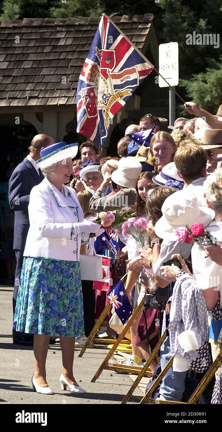 Die Königin sammelt Blumen von den Wohlbehüten, als sie von der St. John the Baptist Church in Canberra abfährt. Stockfoto