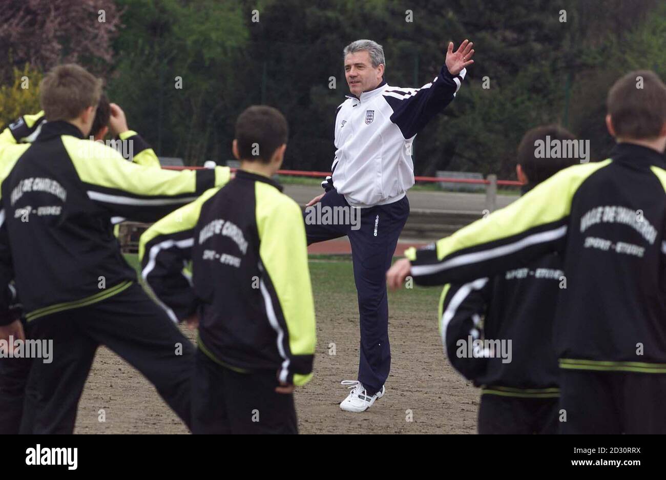 Dieses Bild kann nur im Rahmen einer redaktionellen Funktion verwendet werden. Kevin Keegan, der Manager des englischen Fußballteams, führt belgische Schulkinder während eines Sportunterrichts an einer Schule in Charleroi auf Herz und Nieren. *Keegan ist in Belgien für einen zweitägigen Besuch im Land vor der EM 2000. Keegan besuchte das Stadion, in dem England Deutschland spielen wird. Stockfoto