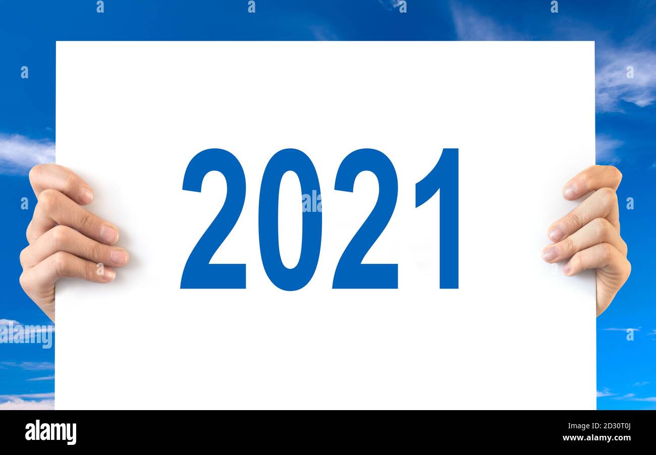 Hände halten ein weißes Brett mit 2021, blauer Himmel Hintergrund Stockfoto