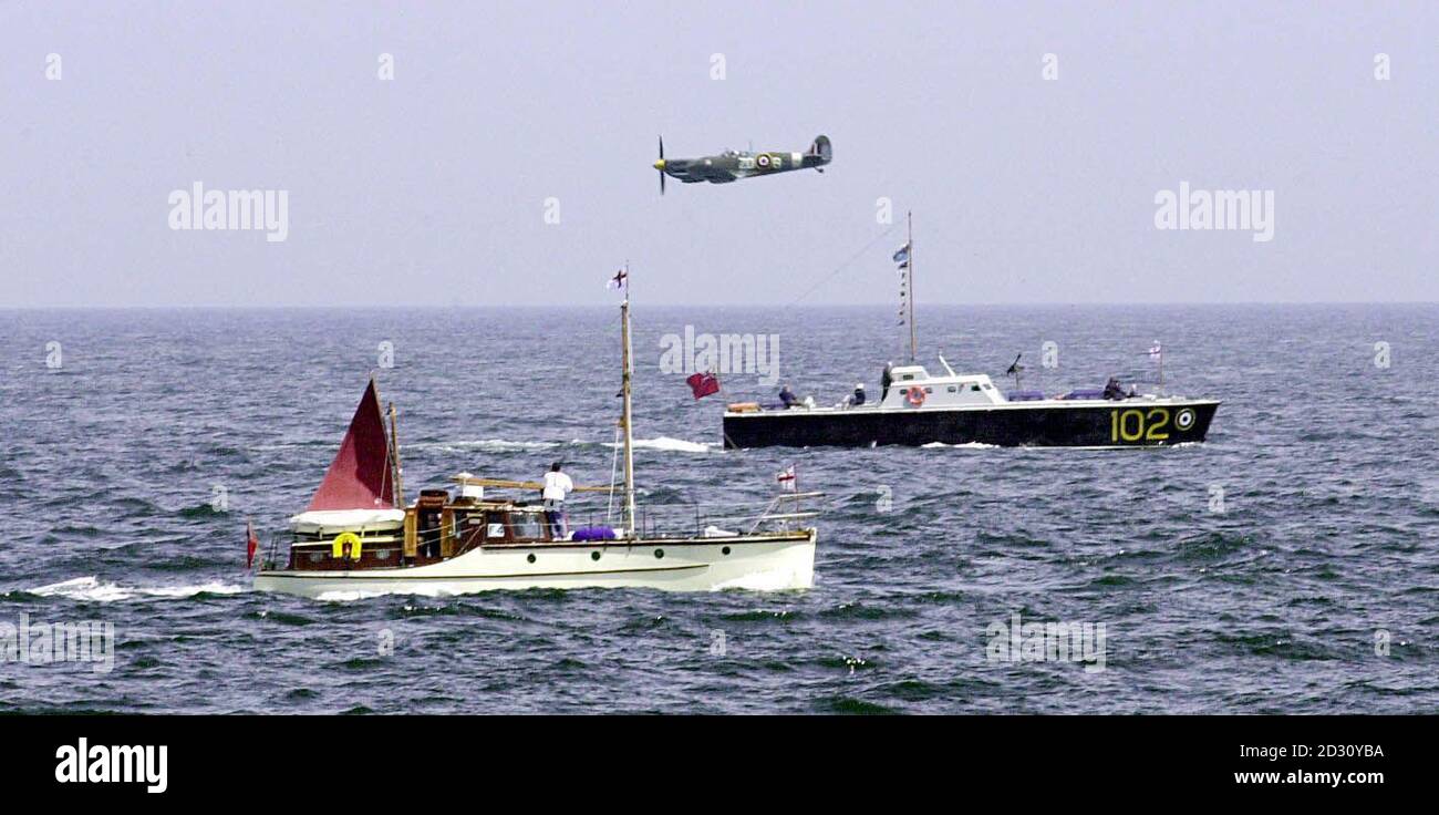 Ein Spitfire, geflogen vom ehemaligen Anführer der Roten Pfeile Ray Hanna, brummt die Prozession der kleinen Schiffe auf ihrer Reise nach Dünkirchen, Nordfrankreich, am 2. Juni 2000, zum 60. Jahrestag der Evakuierung von Dünkirchen. Stockfoto