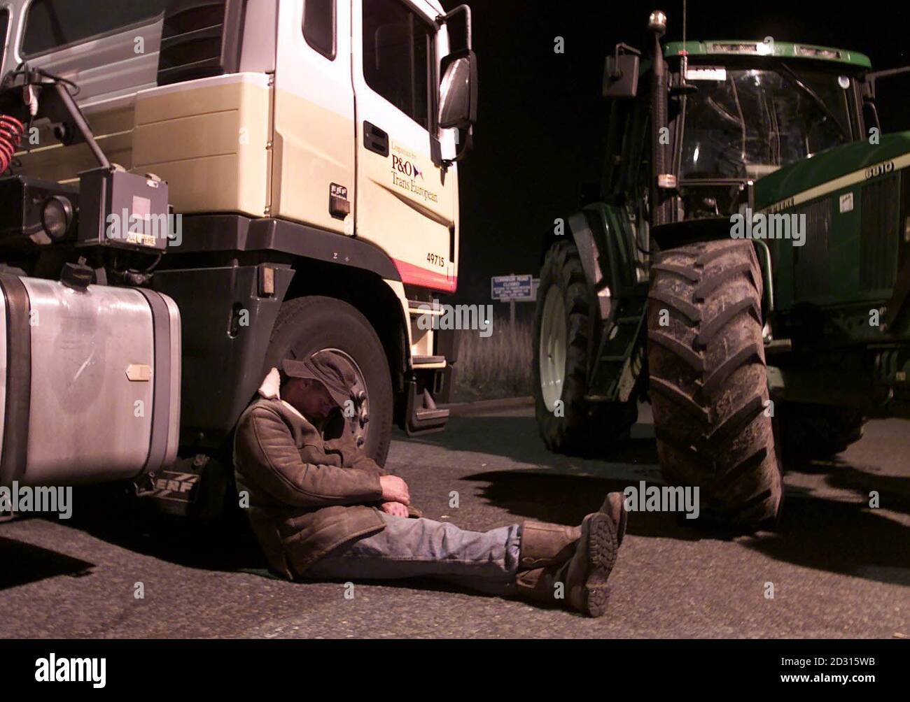 Ein walisischer Landwirt schläft bei einem nächtlichen Protest gegen hohe Kraftstoffpreise gegen das Steuer eines blockierten Shell-Tankers in der Shell-Ölraffinerie Stanlow in Cheshire. Britische Bauern und Trucker gelobten, ihre französischen Störungen fortzusetzen. * ...über hohe Treibstoffkosten, nachdem Hunderte sich herausstellten, um eine Ölraffinerie in Stanlow, nahe Ellesmere Port, Cheshire zu blockieren. Stockfoto
