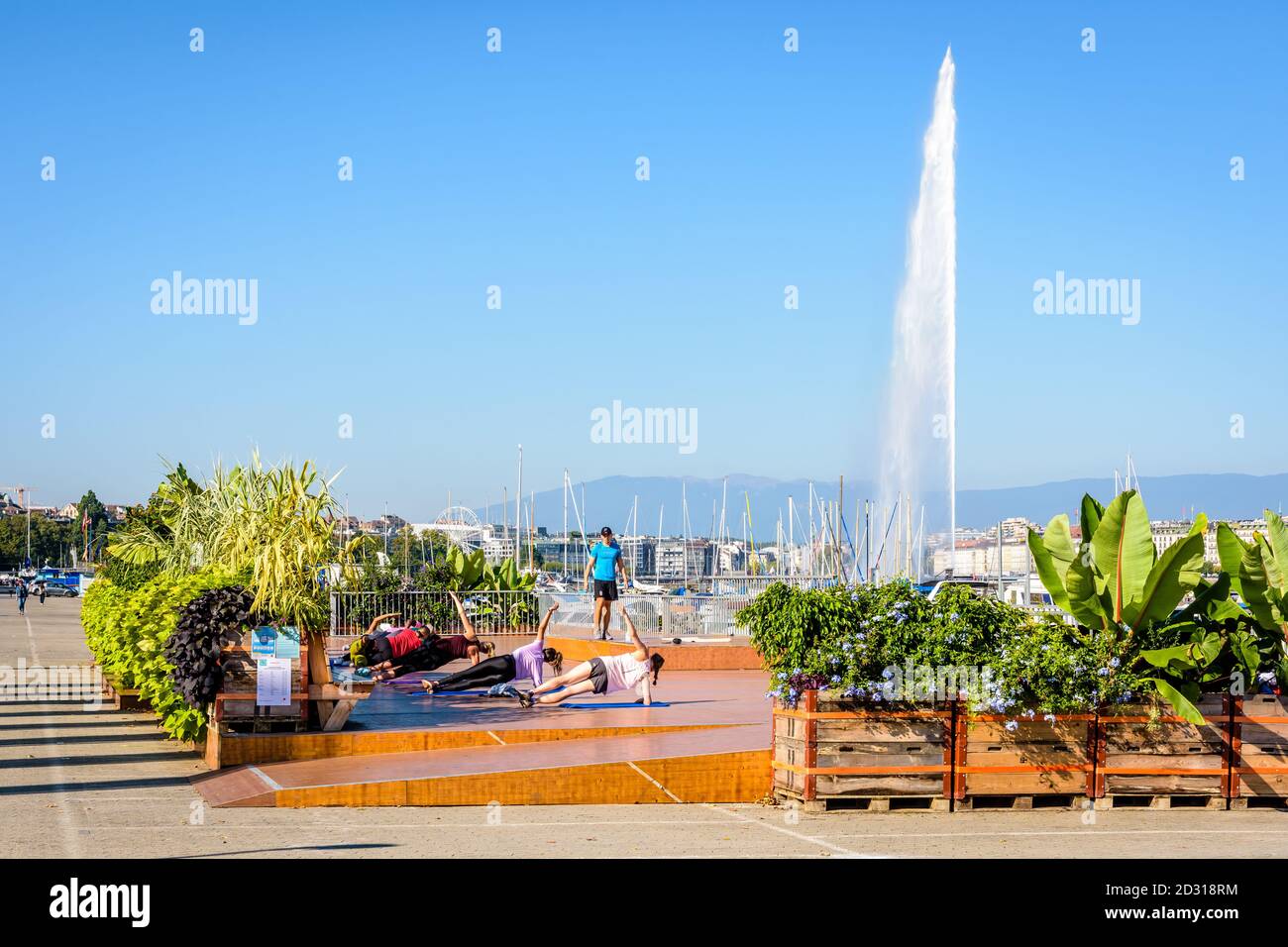 Outdoor-Fitnesskurs am See in Genf, Schweiz, an einem sonnigen Sommermorgen mit dem Jet d'Eau, dem 140 Meter hohen Wasserstrahl in der Ferne. Stockfoto