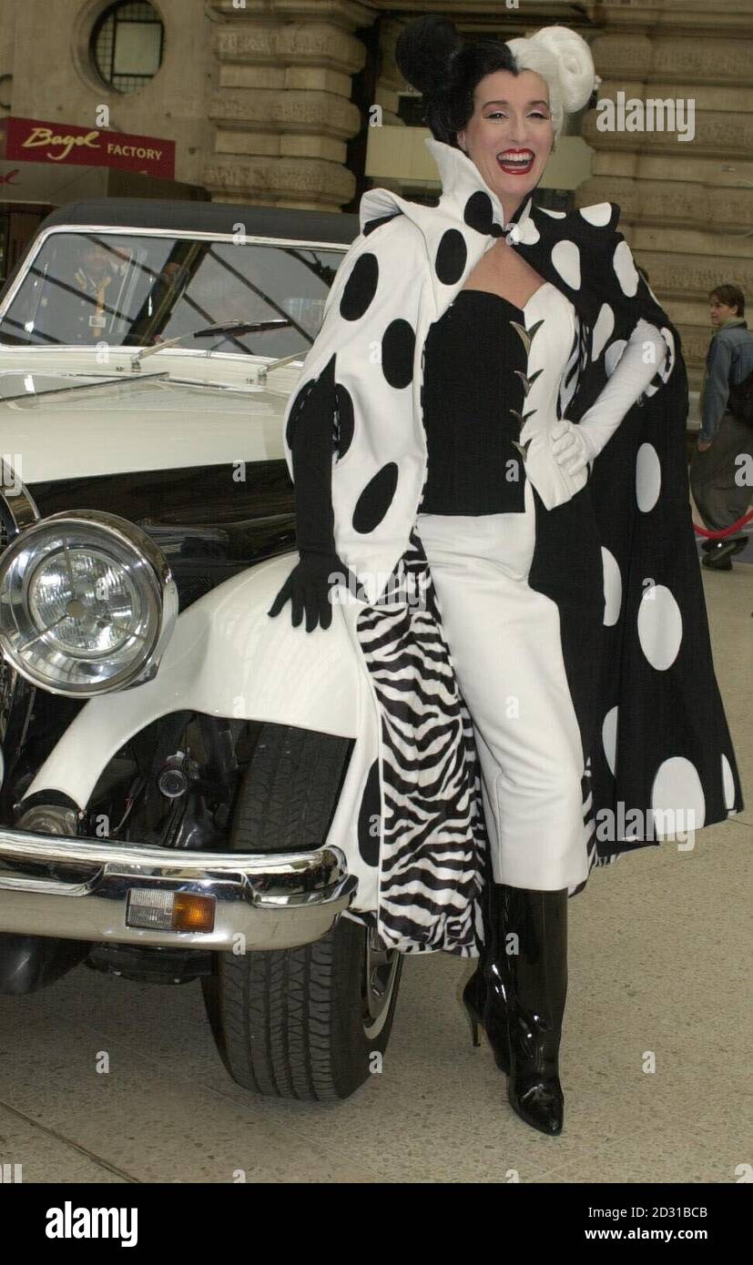 Die Filmfigur Cruella Devil kommt an der Waterloo Station in London an, um Disneys Eurostar-Zug „102 Dalmatiner“ zu starten. Alle achtzehn Reisebusse des Viertelmeile-Zuges sind mit Bildern dalmatinischer Welpen bedeckt. Stockfoto