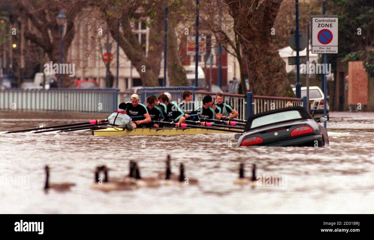 Ruderer von der Cambridge University fahren an der Themse am Putney Embankment vorbei und passieren ein versunkenes Auto in London, während sie an den Versuchen teilnehmen, um im Team für das nächste Jahr des University Boat Race gegen Oxford anzutreten. Stockfoto