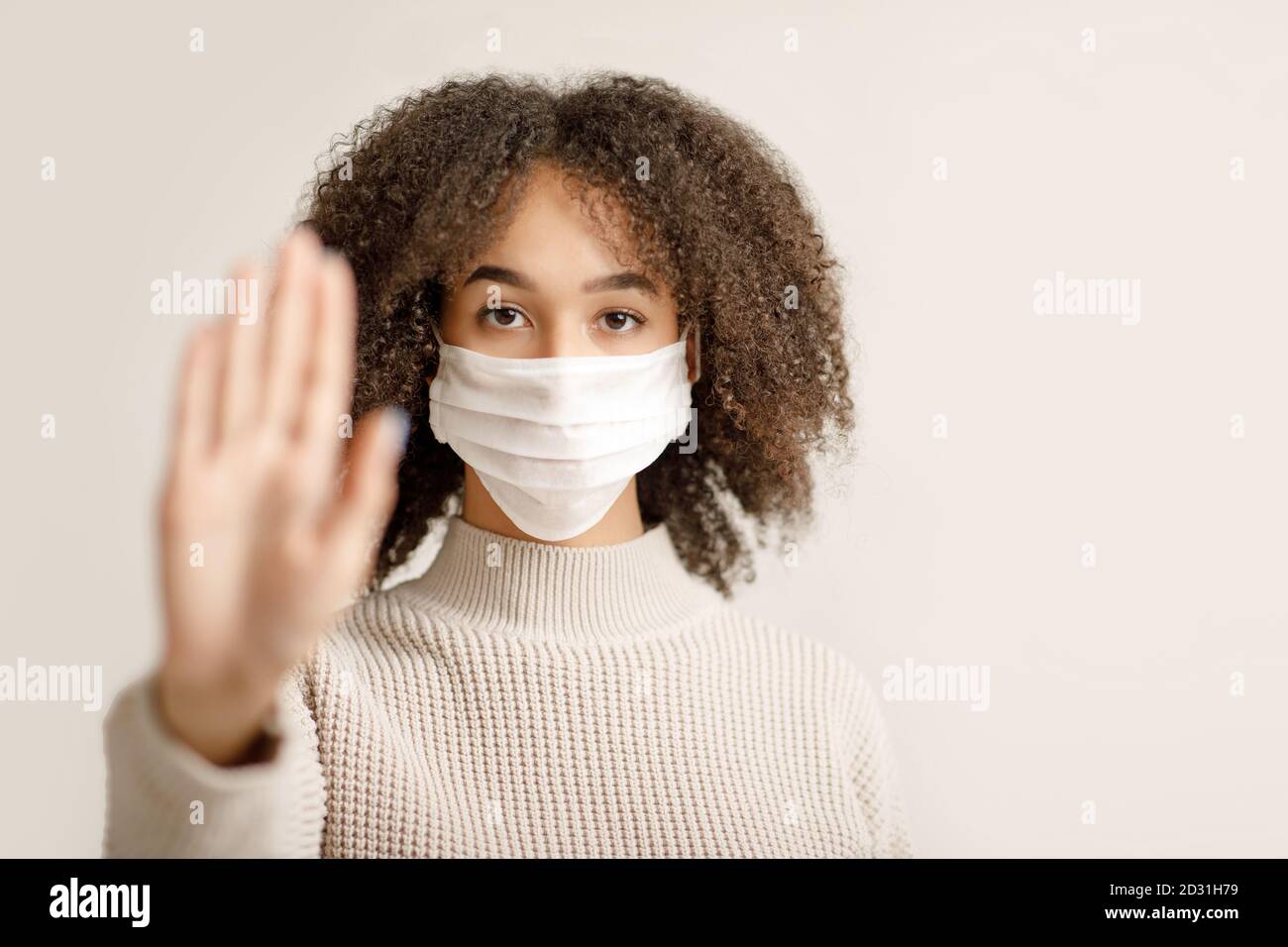 Stoppen Sie Coronavirus und Gesundheitsschutz während der Epidemie. Seriöse afroamerikanische junge Frau in Schutzmaske Stockfoto
