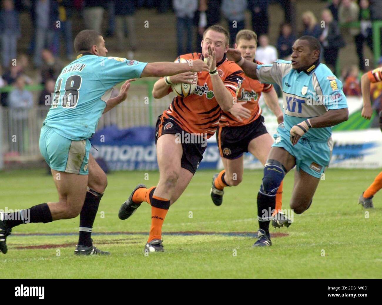 Castlefords Jason Flowers wird von Hulls Steve Craven (links) und Stanley Gene während ihres bitteren Rubinliga-Spiels der Tetley Super League in der Wheldon Road in Castleford heruntergezogen. * Pic von John Jones Stockfoto