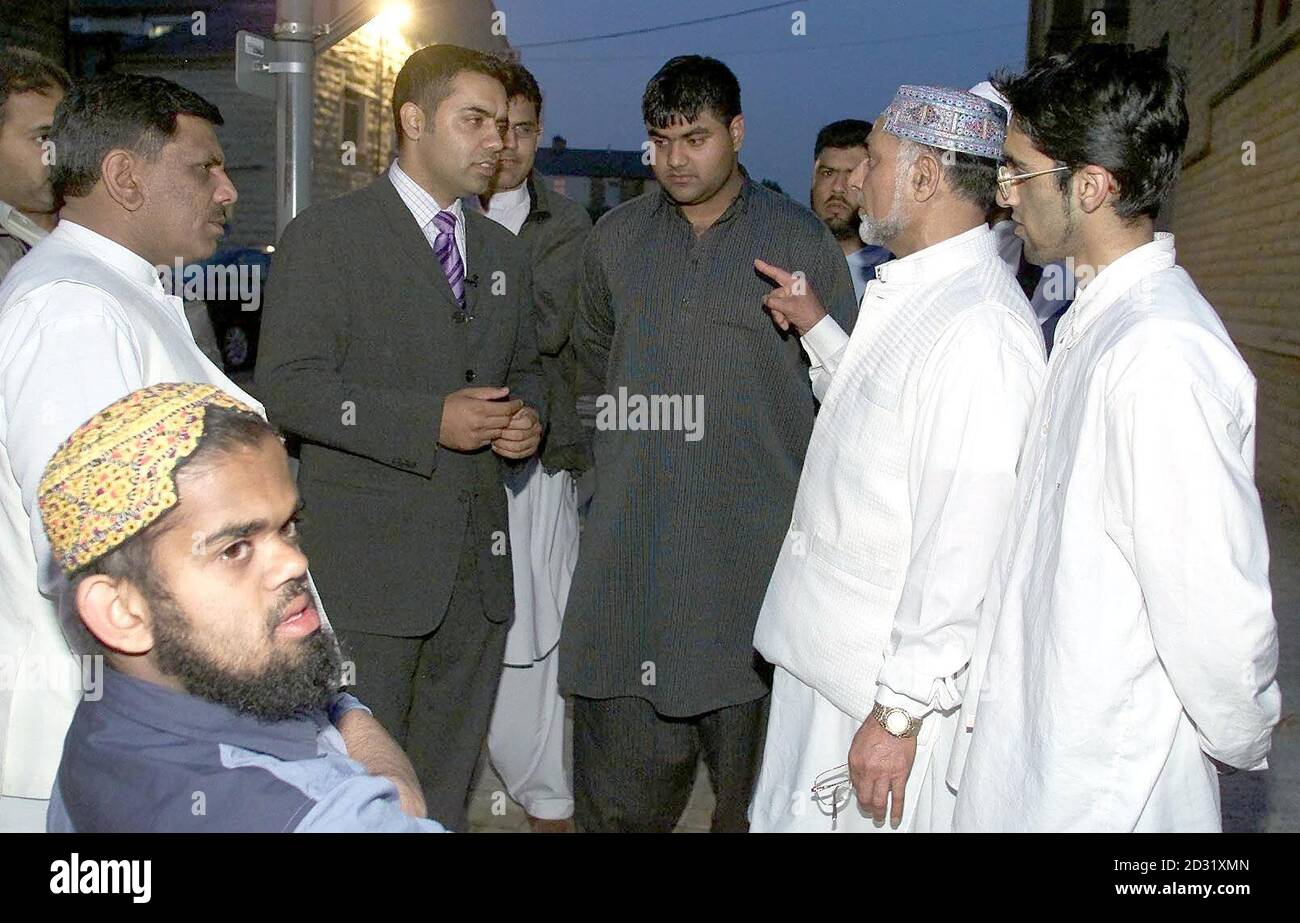 Shahid Malik, (3. Links oben) wieder auf den Straßen von Burnley, Dienstag, 26 2001. Juni, im Gespräch mit asiatischen Gemeindeführern in der Nähe der Verletzten in der letzten Nacht. Malik behauptete, er sei in der Nacht von sporadischer Gewalt am Montag von der Polizei zu Boden gestoßen und verletzt worden. Herr Malik, 33, Mitglied des Nationalen Exekutivkomitees der Labour-Partei und der Kommission für Rassengleichheit, benötigte nach dem Vorfall eine Krankenhausbehandlung. Er wurde verhaftet, aber später zu einem späteren Zeitpunkt freigelassen, um interviewt zu werden und behauptete, er sei bewusstlos mit einem Schild geschlagen worden, als er um Ruhe bat. Einundzwanzig Menschen, beide weiß und Stockfoto