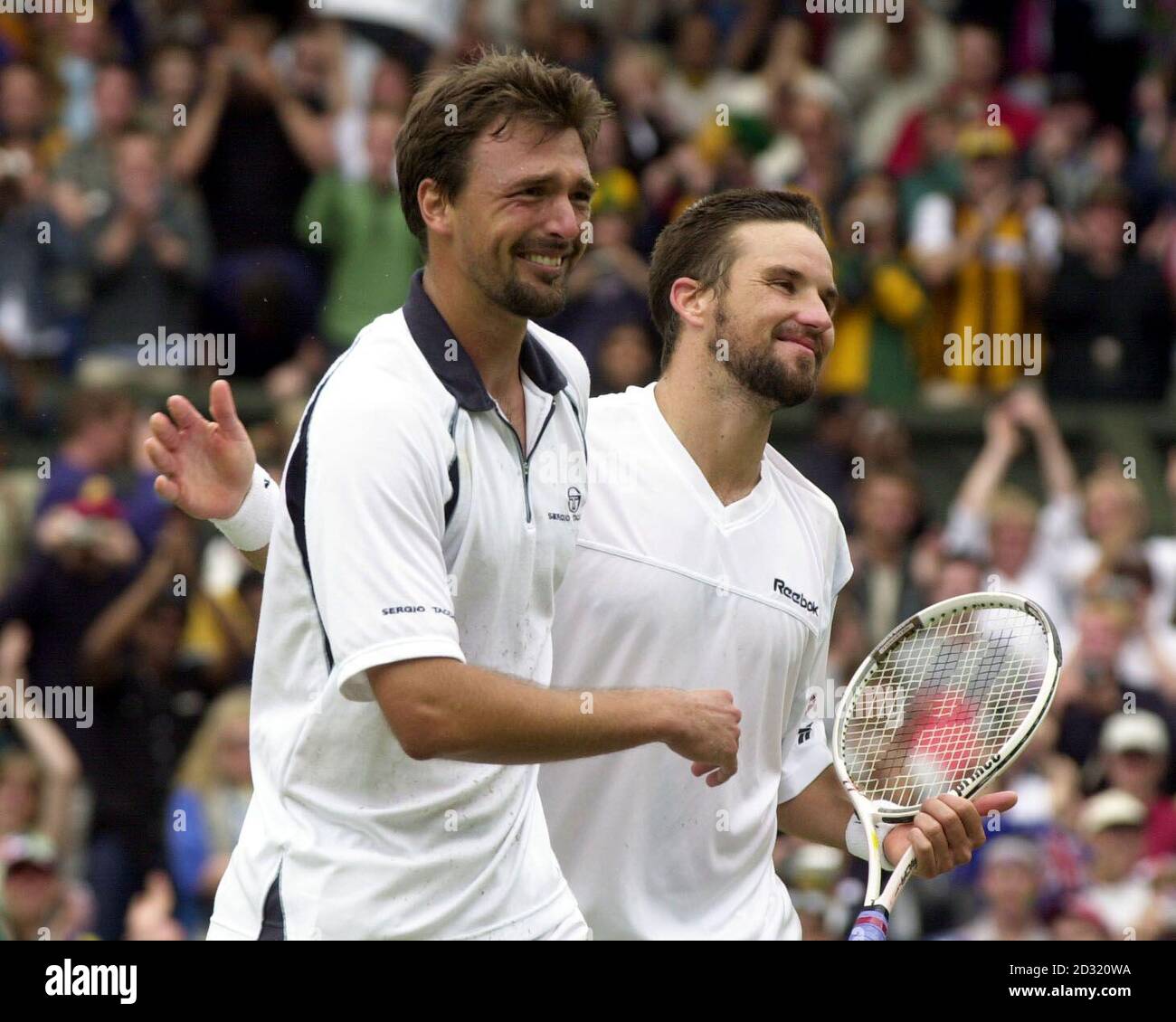 KEINE KOMMERZIELLE NUTZUNG: Goran Ivanisevic aus Kroatien (links) feiert, nachdem er Australiens Pat Rafter beim Herrenfinale der Lawn Tennis Championships 2001 in Wimbledon in London besiegt hat. Ivanisevic gewann 6-3, 3-6, 6-3, 2-6, 9-7 . Stockfoto