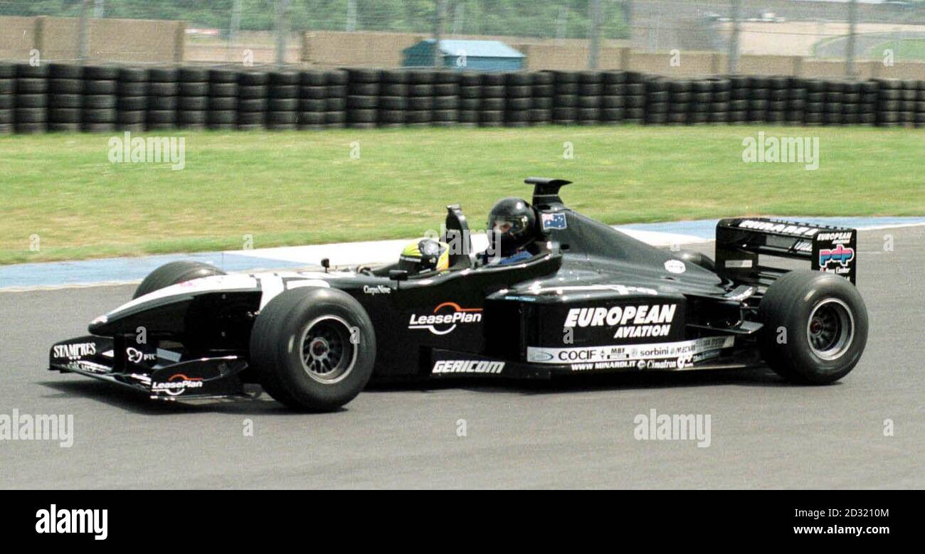 Der brasilianische Formel-1-Grand-Prix-Fahrer Tarso Marques nimmt PA Sport Motor Racing-Korrespondent Ian Gordon mit auf eine Testfahrt im europäischen Minardi V10-Zweisitzer-F1-Auto um den Donington Park. Stockfoto