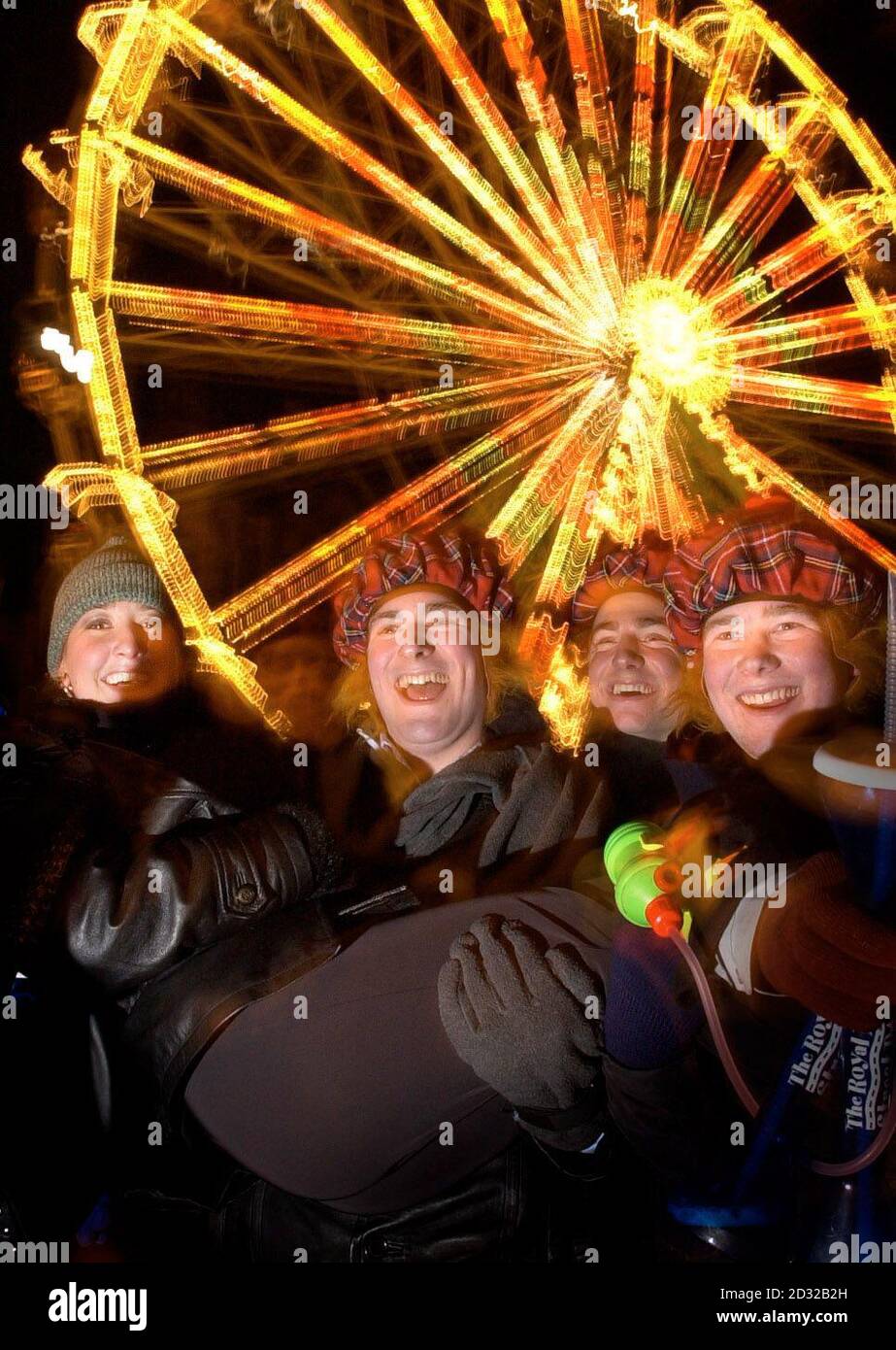 Silvester Nachtschwärmer kommen in den festlichen Geist in der Nähe des Big Wheel in Edinburghs Princes Street. Stockfoto