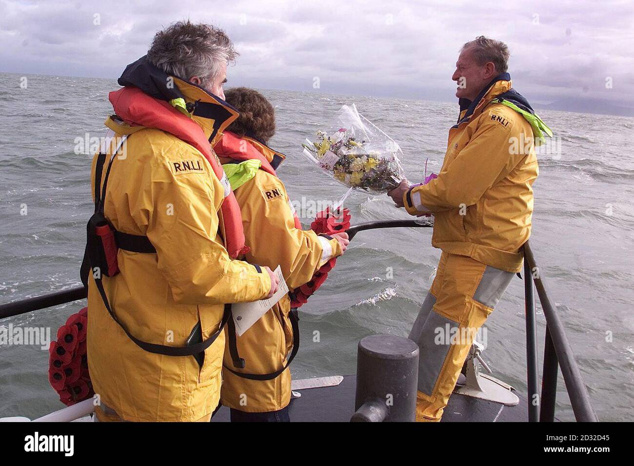 Kapitän Roy Klaviter (rechts), ehemaliger amerikanischer Marineoffizier, bereitet sich darauf vor, einen Blumenstrauß in das irische Meer zu werfen, über dem Punkt, an dem das britische U-Boot H5 am 2 1918. März vor der Küste von Nordwales versank, wobei alle 27 Besatzungen an Bord getötet wurden. * Klaviter - dessen Frau Betty eine Enkelin eines jungen amerikanischen Beobachters Lieutenant Weeks Childs ist, der mit dem Boot hinunterging - sagte, dass er geehrt wurde, zu der Zeremonie eingeladen zu sein, die von Friends of the H5 organisiert wurde. Nur Jahre später stellte sich heraus, dass das Schiff von einem britischen Handelsschiff - der SS Rutherglen - versenkt wurde, was sich verwechselt hatte Stockfoto