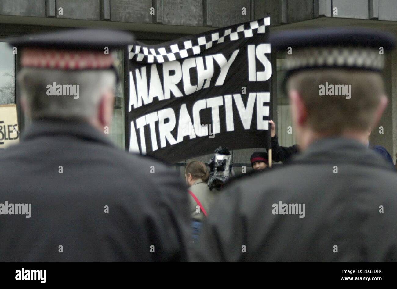 Uniformierte Offiziere behalten ein Auge auf die Verfahren vor einer Massenlobby in Westminster, London, von anderen Polizeibeamten, die gegen Bezahlung und Regierungsreformen protestieren. * ... Das Banner wird vermutlich von antikapitalistischen Demonstranten gehalten, die versuchten, den Polizeiprotest zu infiltrieren. Stockfoto