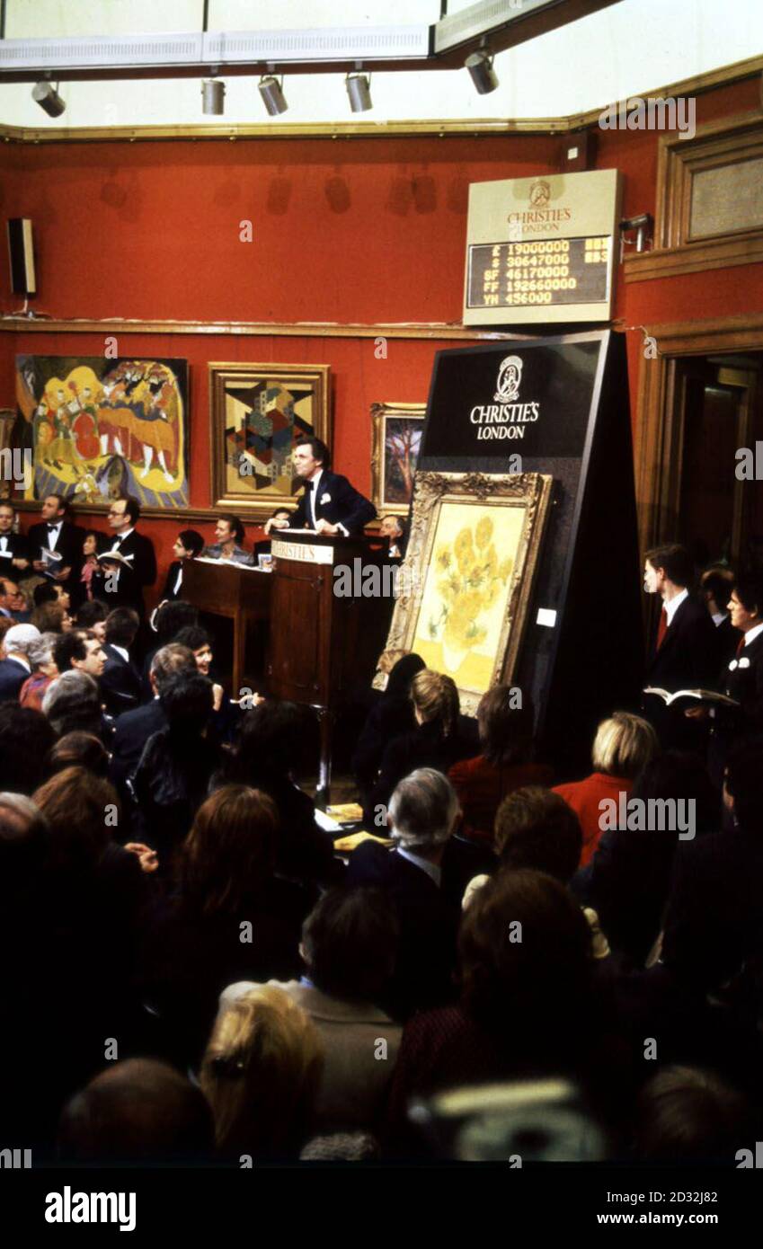 Ein Rekordpreis wurde heute für Vincent van Goghs weltberühmtes Ölgemälde 'Sunflowers' gezahlt. Die 39 x 30 Zoll große Leinwand, die kurz vor dem Selbstmord des niederländischen Künstlers 1890 gemalt wurde, ging für 22.5 Millionen an einen anonymen Käufer bei Christie's. Der Auktionator Charles Allsop steht neben dem Gemälde, während telefonische Ausschreibungen stattfinden. Stockfoto